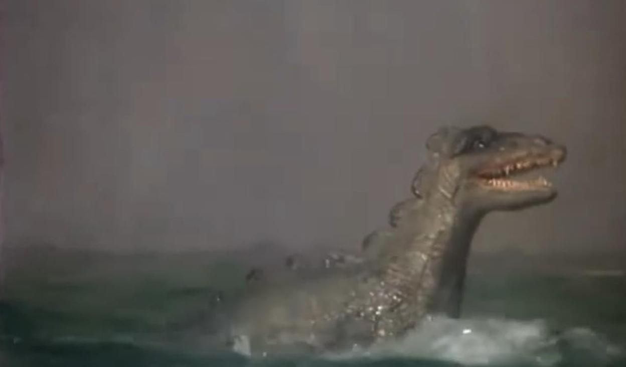 Ein reptilienartiges Wesen mit scharfen Zähnen taucht aus nebligem Wasser auf.