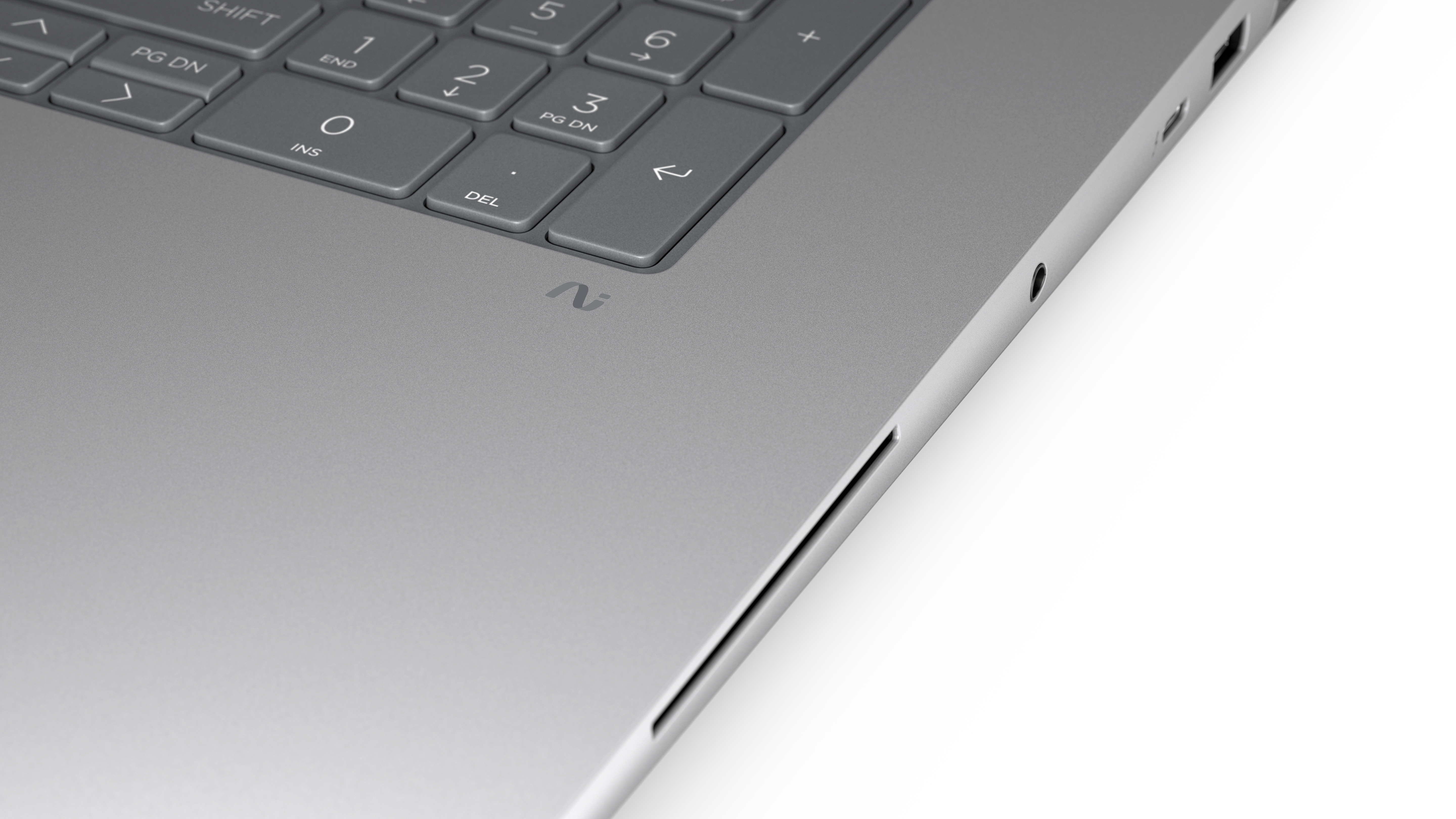 Grauer Laptop mit Tastatur, Logo und Anschlüssen auf weißem Hintergrund.
