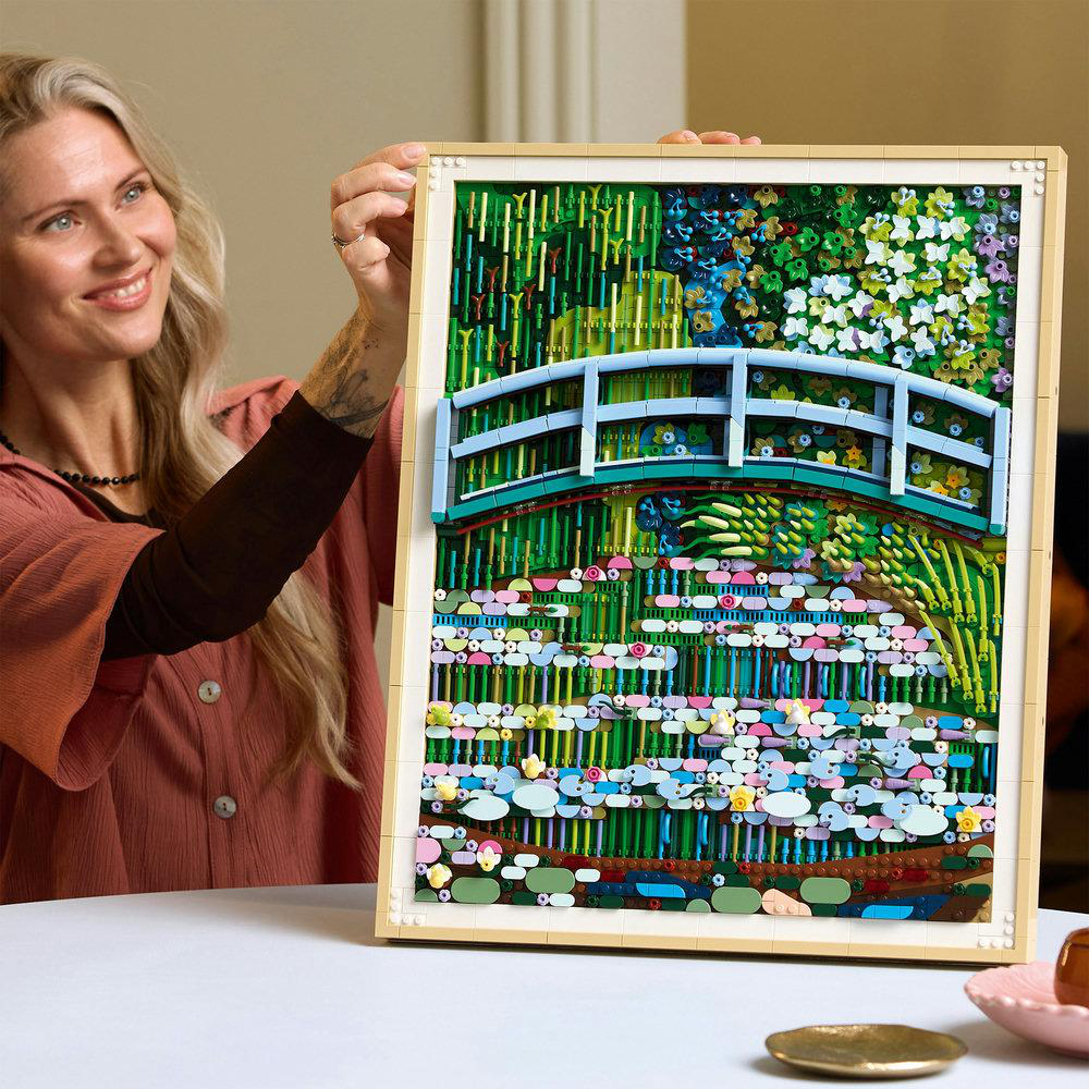 Eine Frau hält ein LEGO-Bild eines Gartens mit Brücke und Seerosen