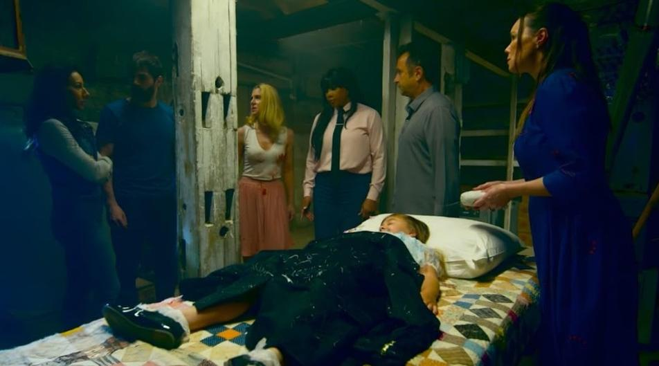 Sechs Personen stehen um ein Bett, auf dem ein Kind liegt. Eine Frau hält eine Seife.