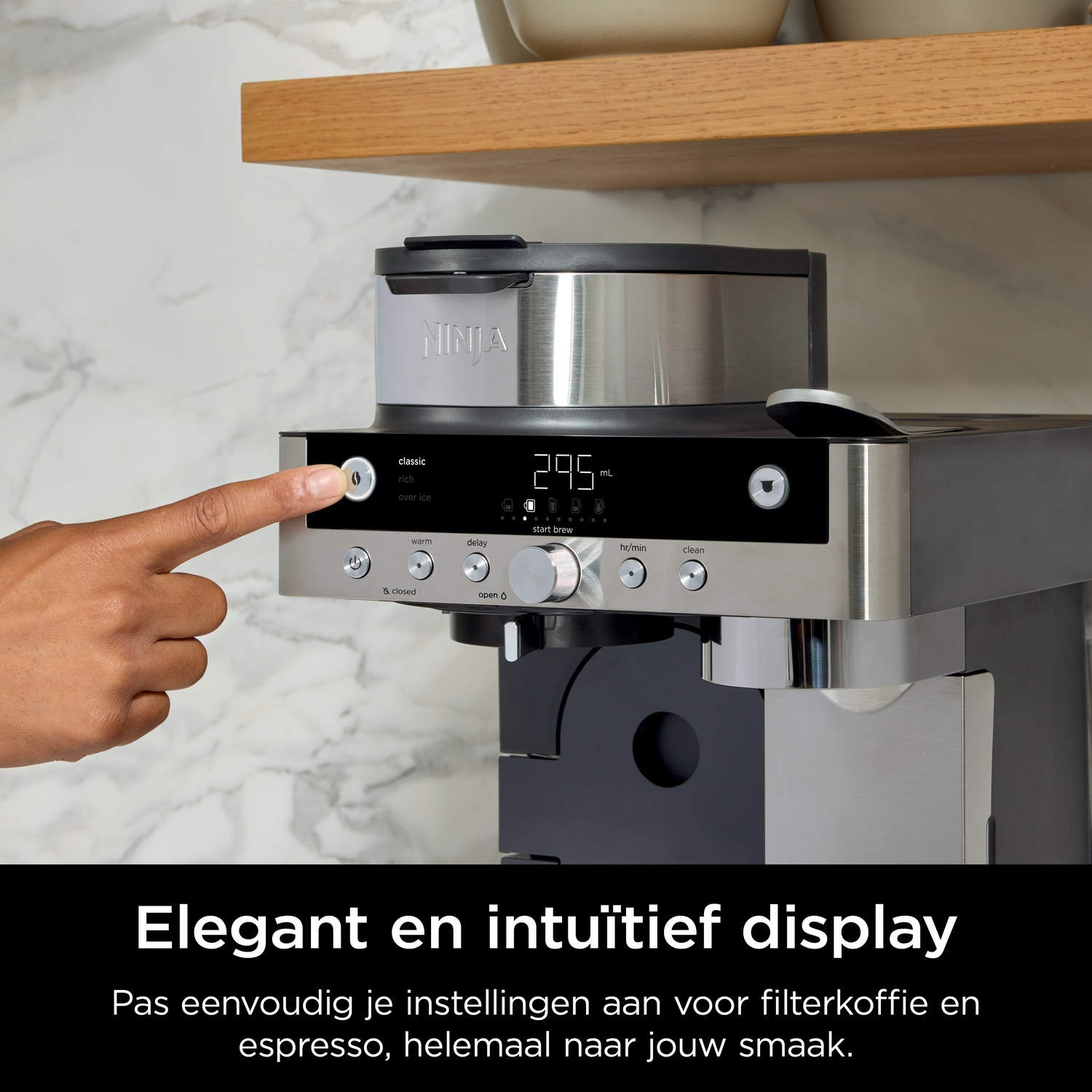 A hand presses a button on a coffee machine with a digital display.
