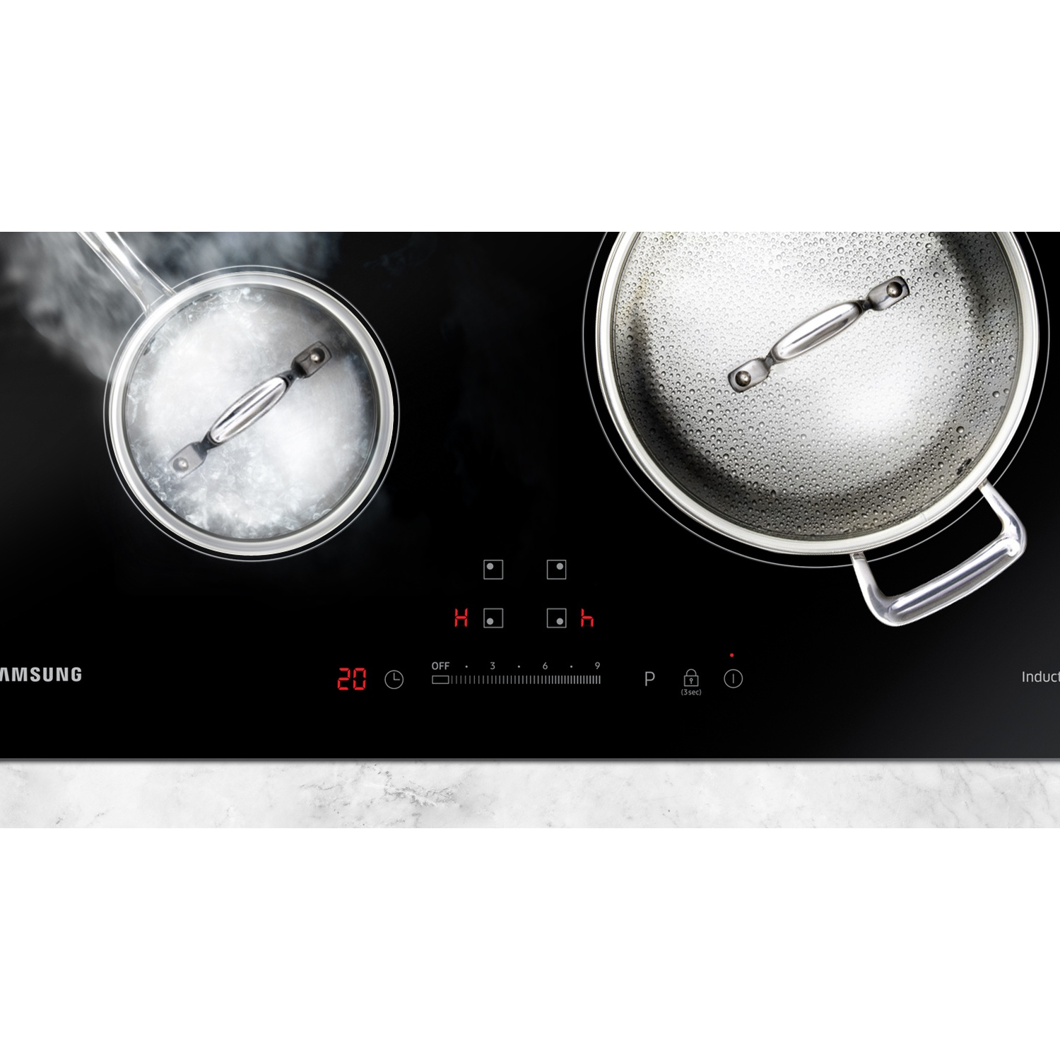 A black induction hob with two pots, one boiling, the other steaming.