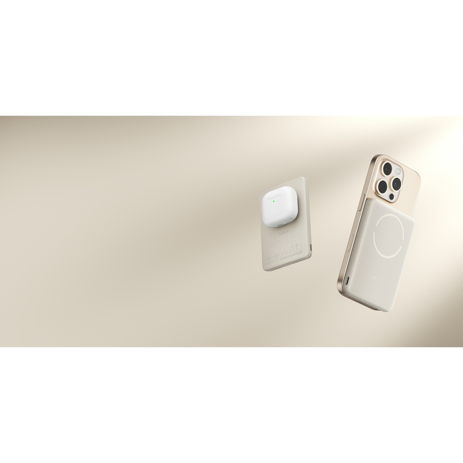 Un iPhone doré avec chargeur MagSafe et un étui de chargement sans fil blanc.