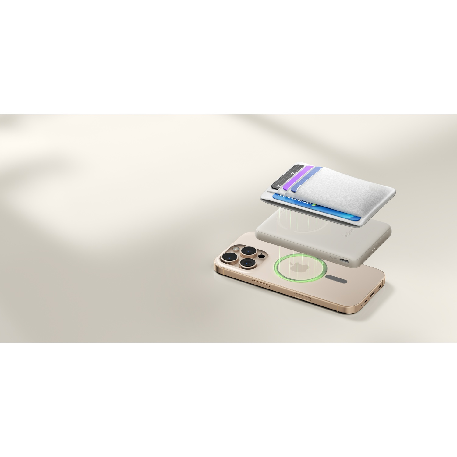 Un iPhone doré avec un porte-cartes blanc attaché à un chargeur sans fil beige.