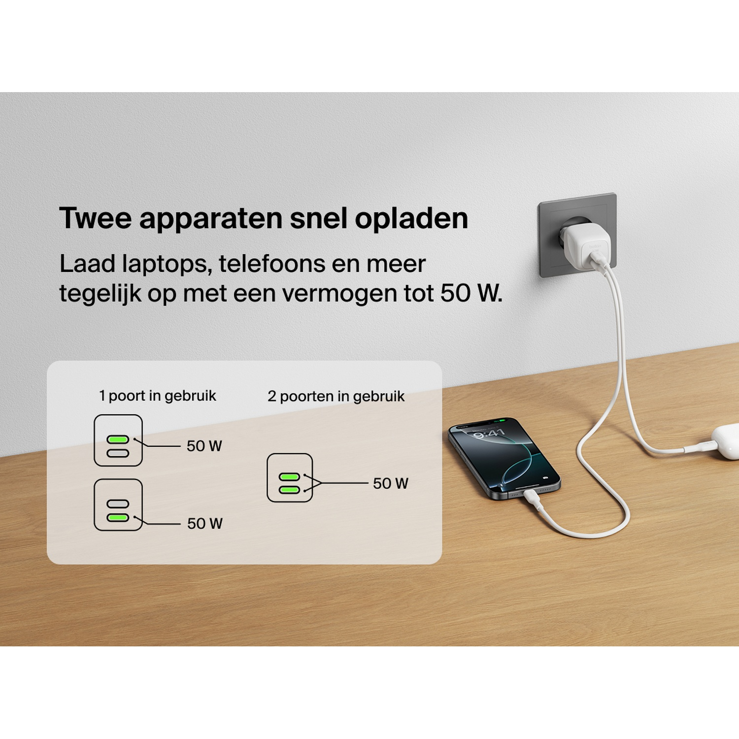 Un chargeur blanc branché au mur, chargeant un iPhone et un autre appareil USB-C.