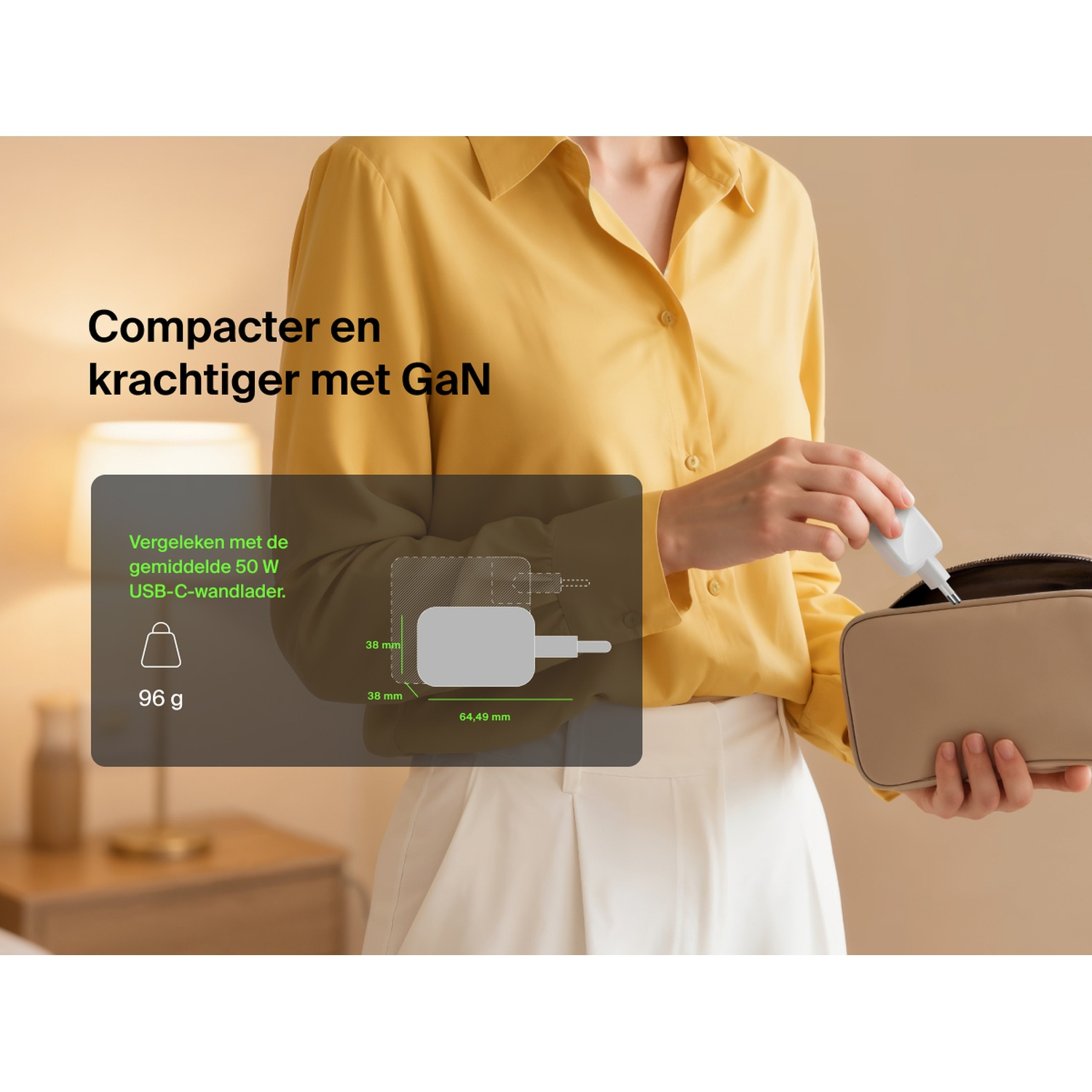 Une personne range un petit chargeur blanc dans un sac. Les dimensions sont indiquées.