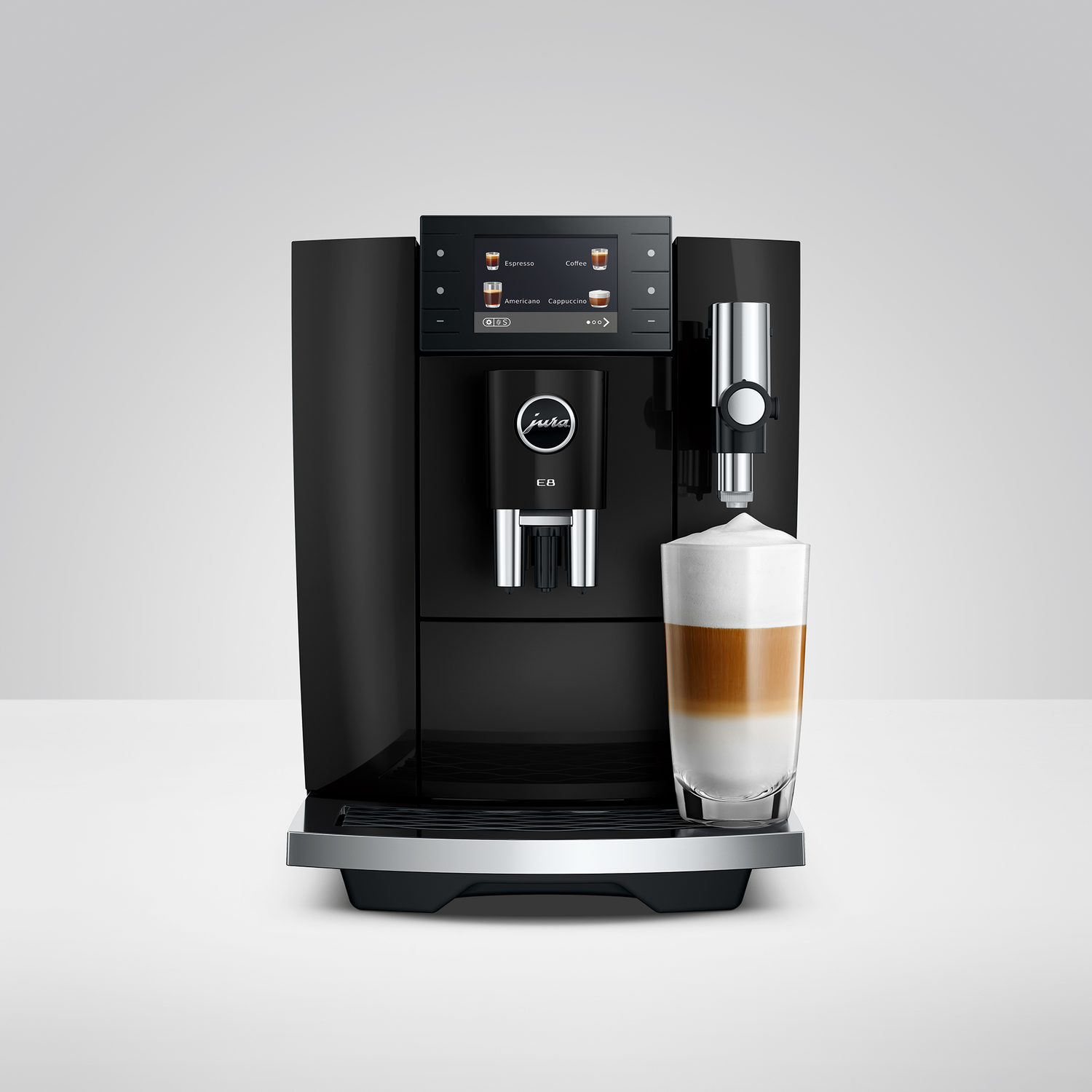Zwarte koffiemachine met scherm bereidt gelaagde koffie in een glas.