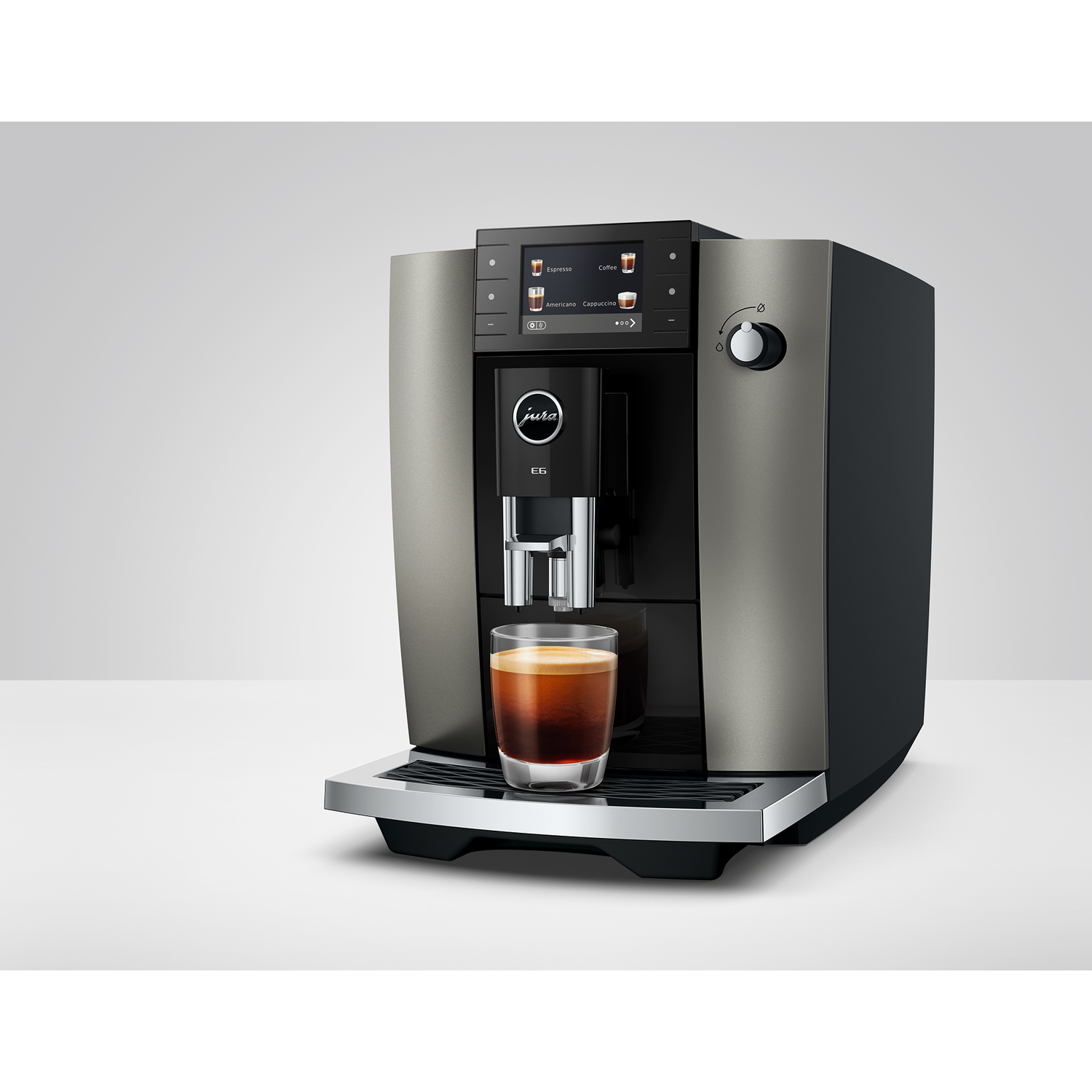 Een Jura koffiezetapparaat met een glas espresso. Grijze en zwarte afwerking.