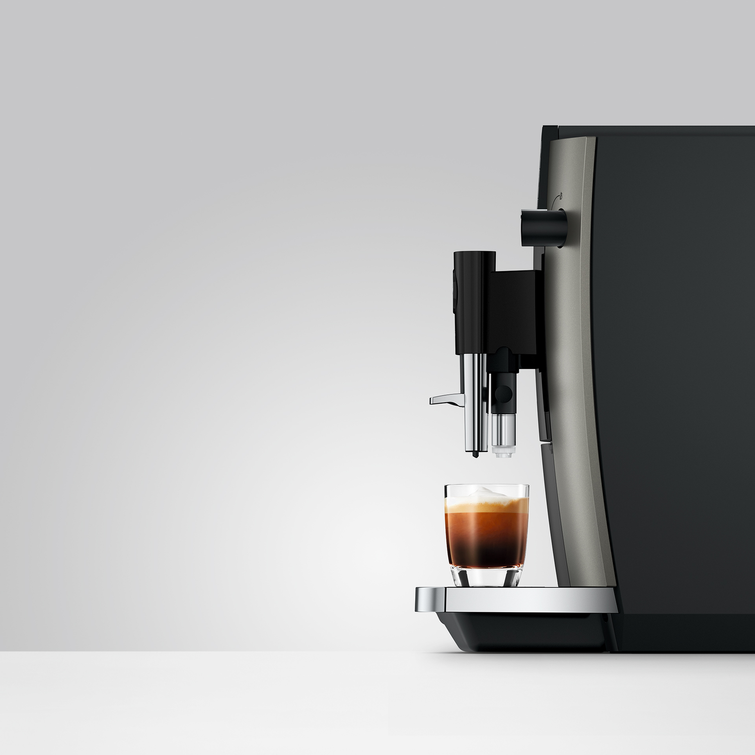 Espresso loopt in een glas. Een koffiezetapparaat staat ernaast.
