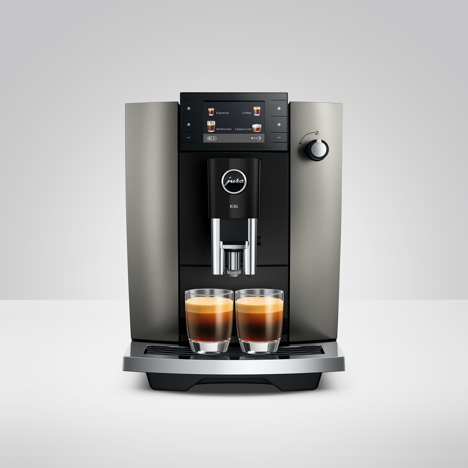 Een moderne koffiemachine zet twee espresso's in glazen op een zilveren lekbak.