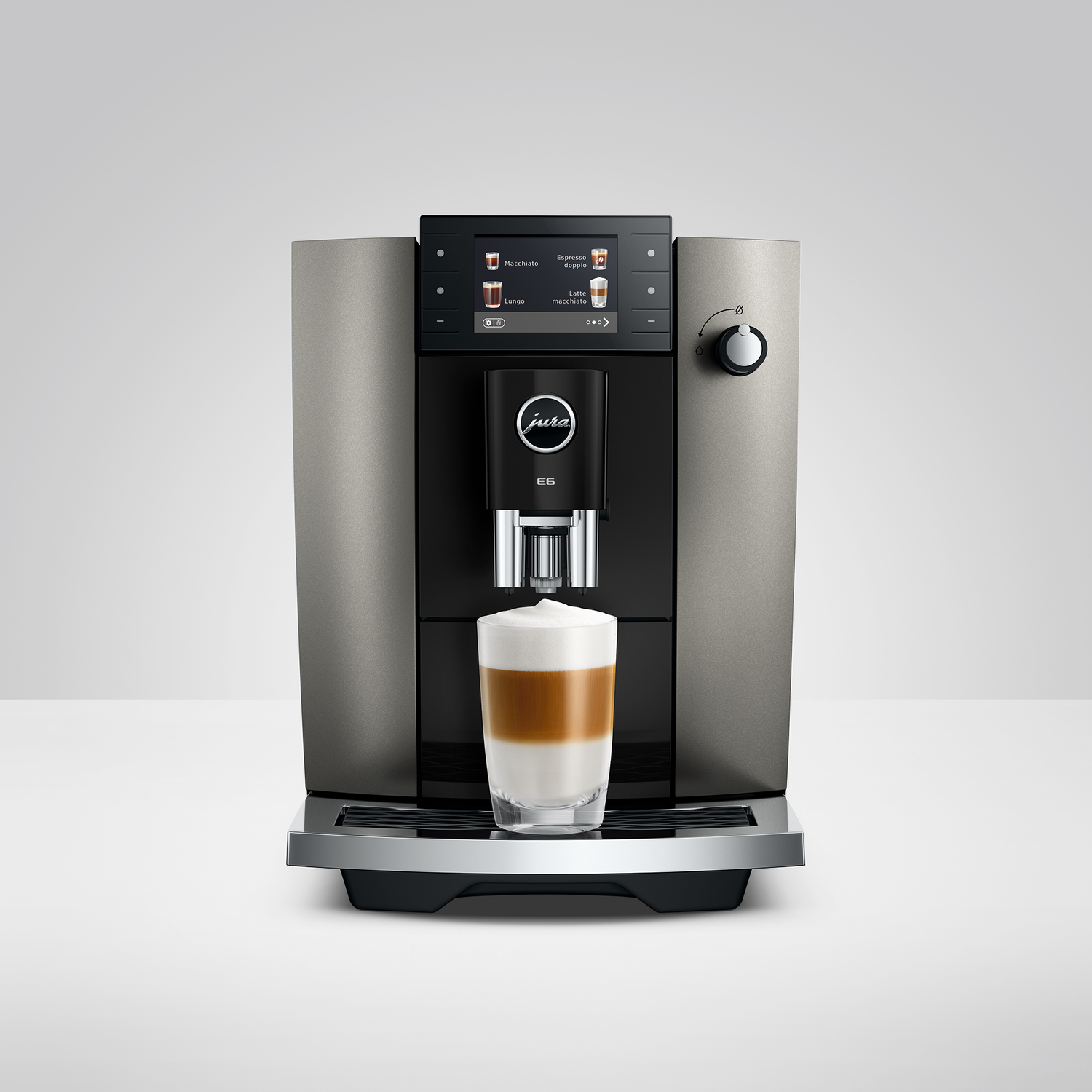 Koffiezetapparaat met een glas met een gelaagde koffiedrank.