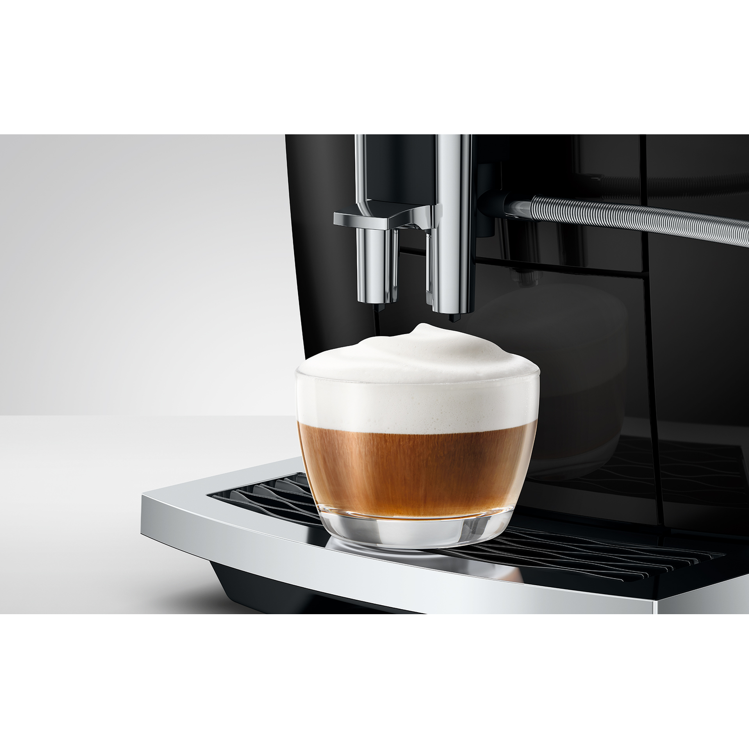 Koffiezetapparaat met glas cappuccino met melkschuim