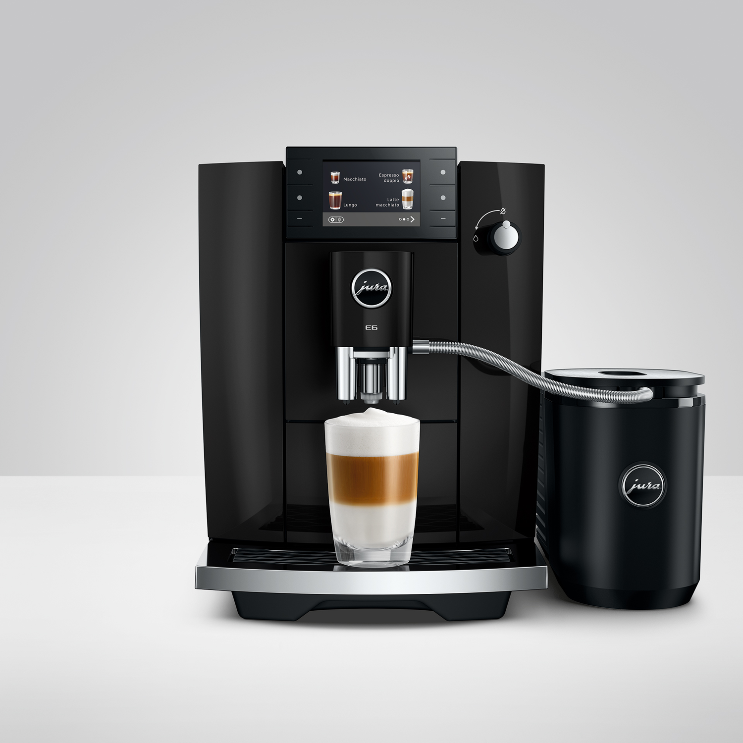 Zwarte Jura koffiemachine met melkreservoir en een latte macchiato.