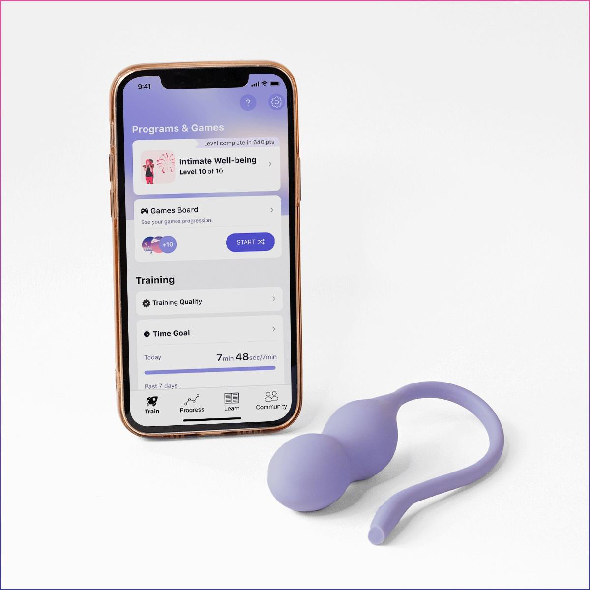 Ein lila Beckenbodentrainer liegt neben einem Smartphone, das eine Fitness-App anzeigt.