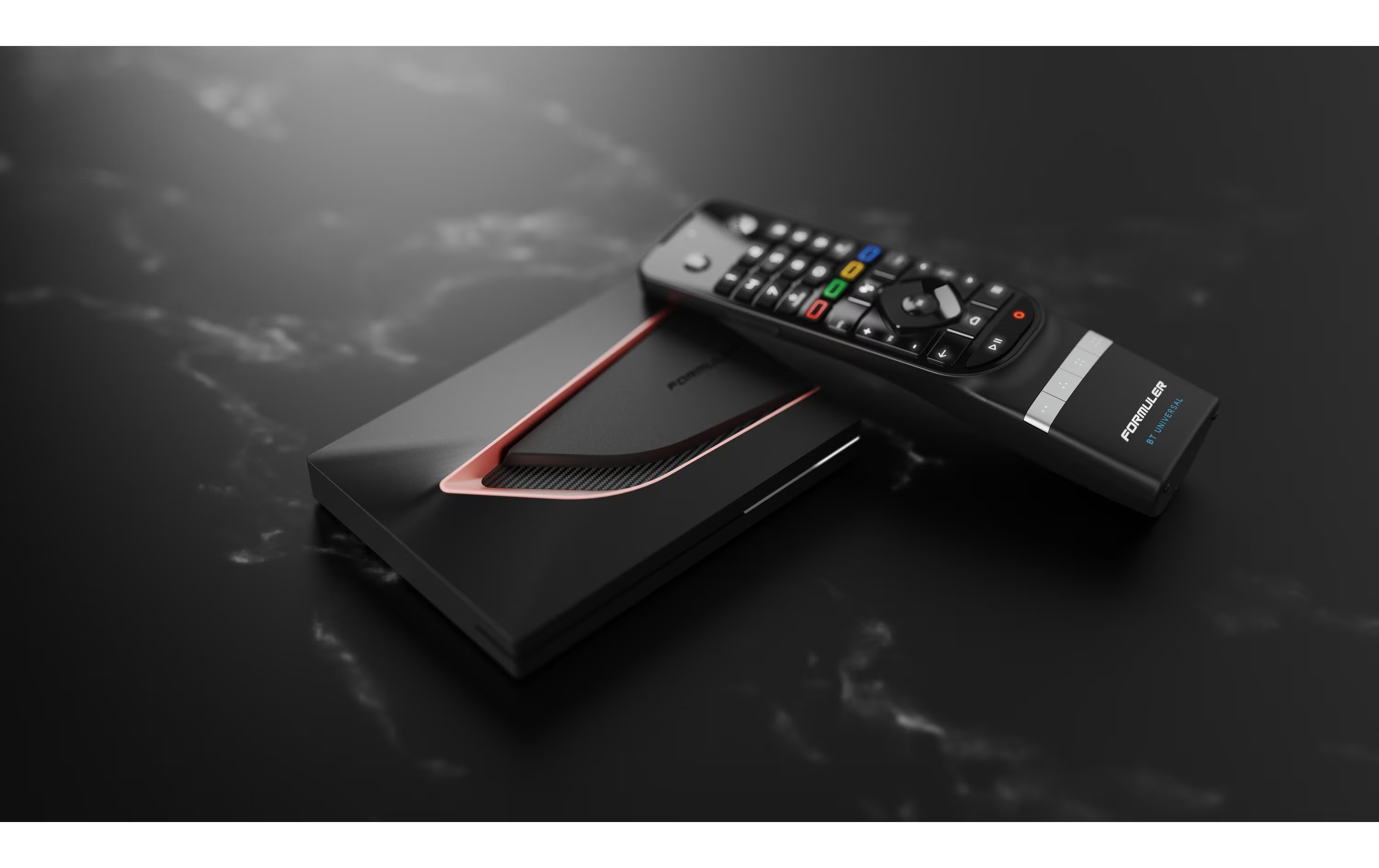 Boîtier décodeur noir avec accents argentés et rouges, à côté d'une télécommande.