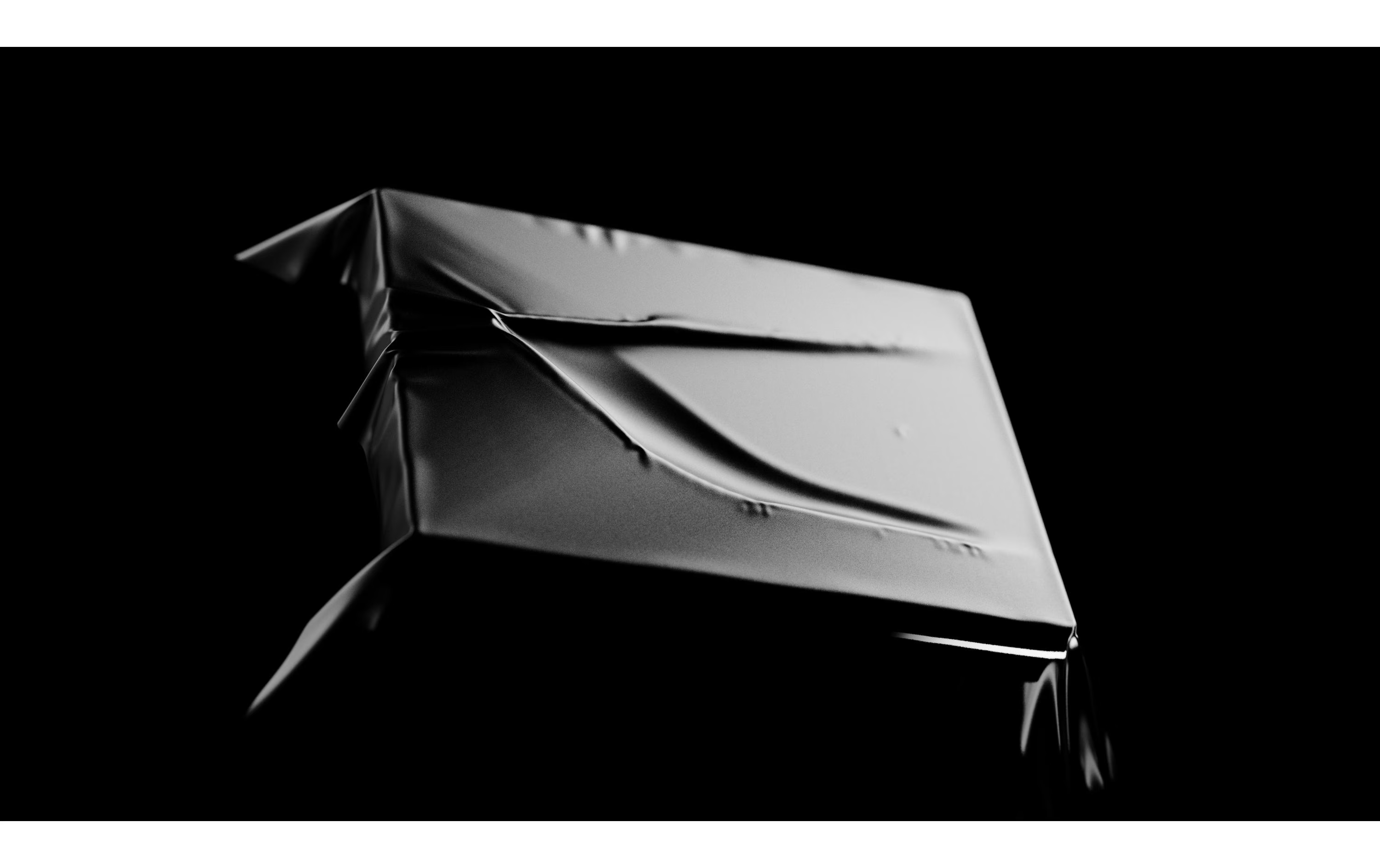 Objet sous tissu gris sur fond noir.