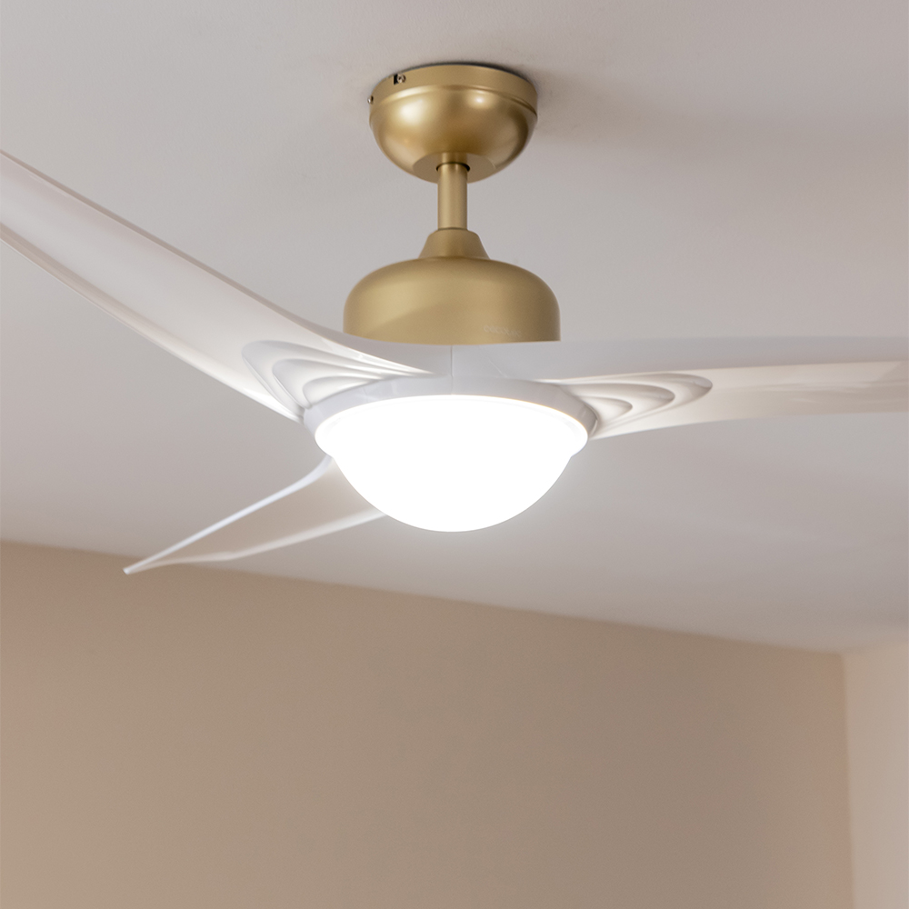 Un ventilador de techo moderno con tres aspas blancas y carcasa dorada.