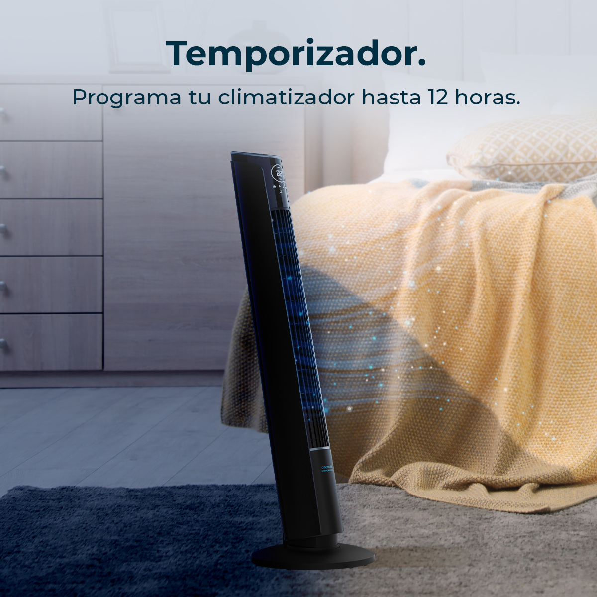 Un ventilador de torre negro junto a una cama con manta amarilla.