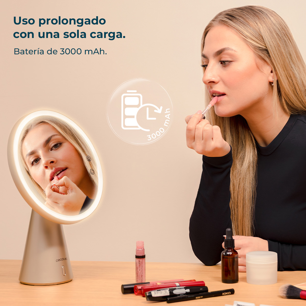 Mujer rubia se maquilla frente a espejo iluminado. Icono de batería de 3000 mAh visible.