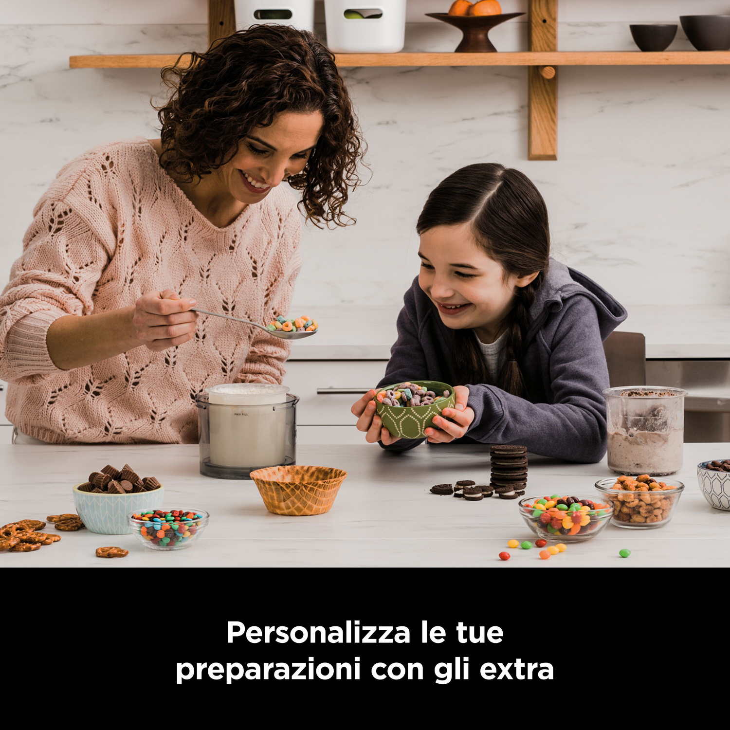 Madre e figlia preparano un dessert con caramelle e biscotti in cucina.