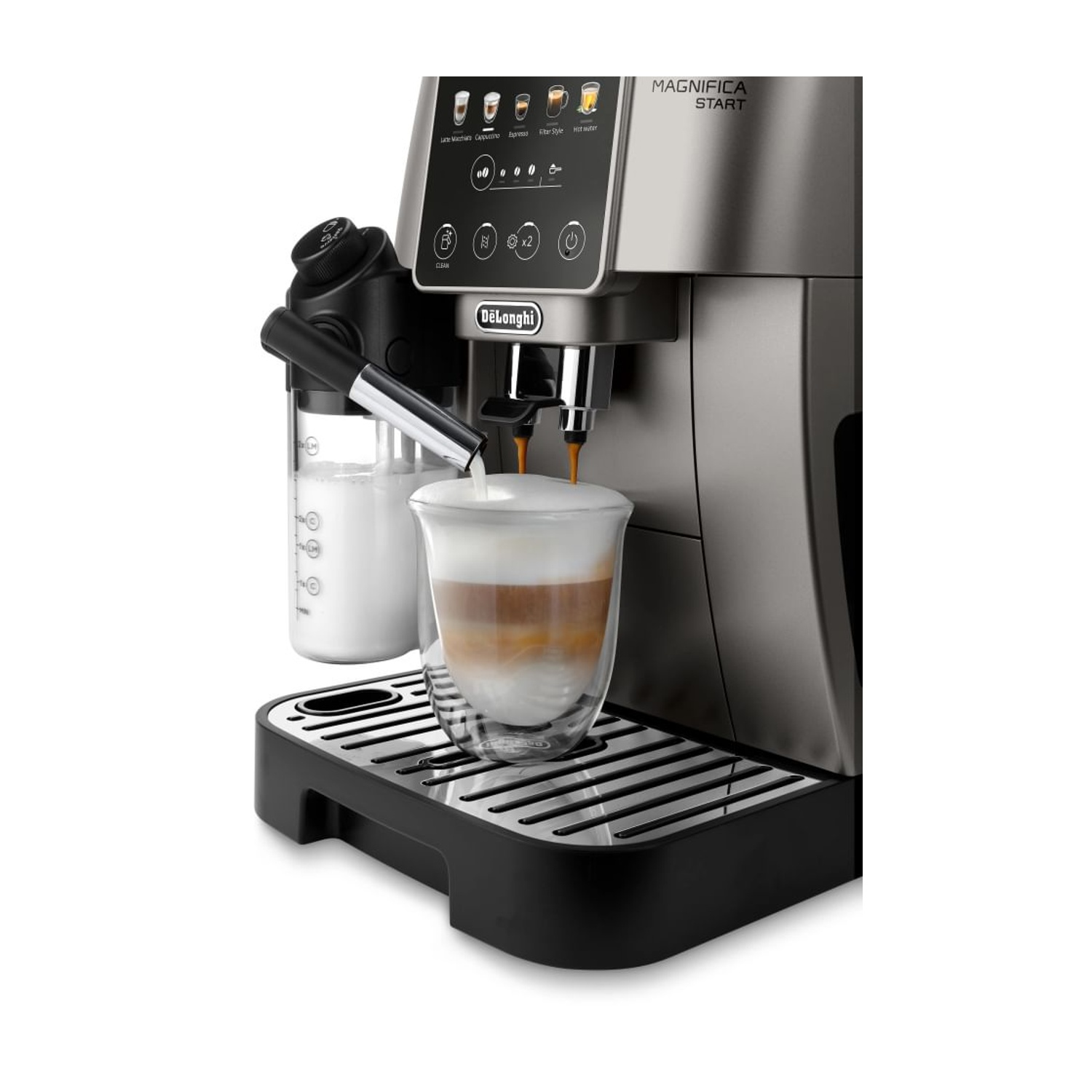 Una macchina da caffè argentata con caraffa del latte e un bicchiere di latte macchiato.