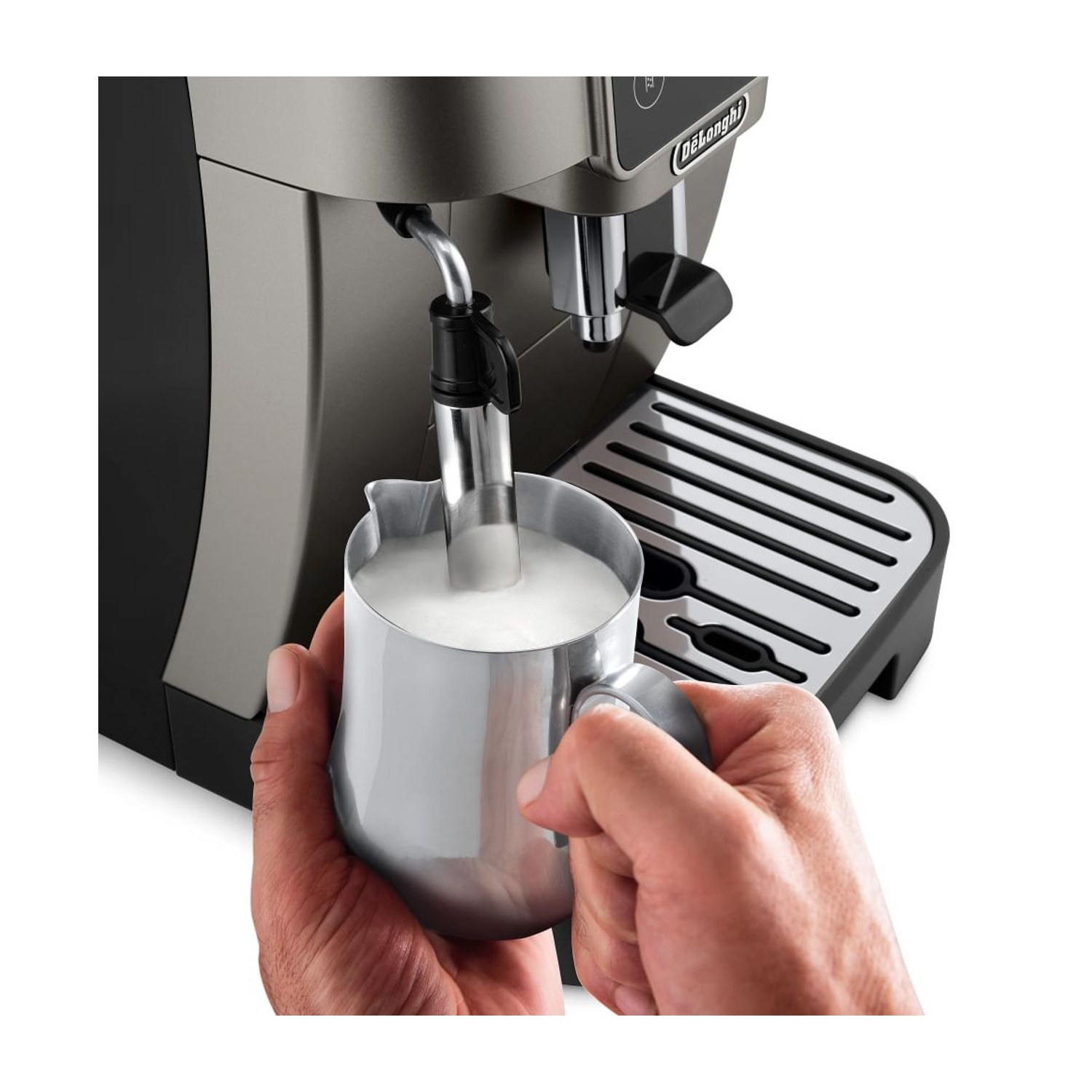 Una mano tiene una lattiera sotto il beccuccio del vapore di una macchina da caffè.