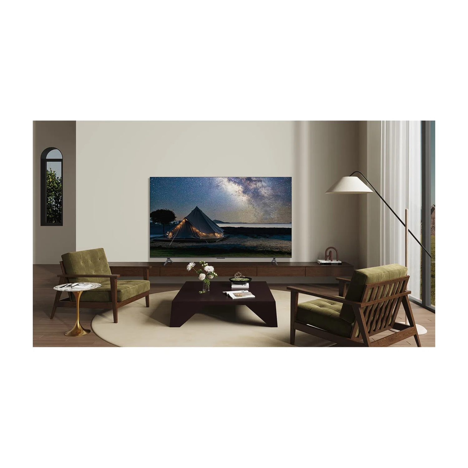 Un soggiorno con due poltrone verdi, un tavolino e una TV che mostra un cielo stellato.
