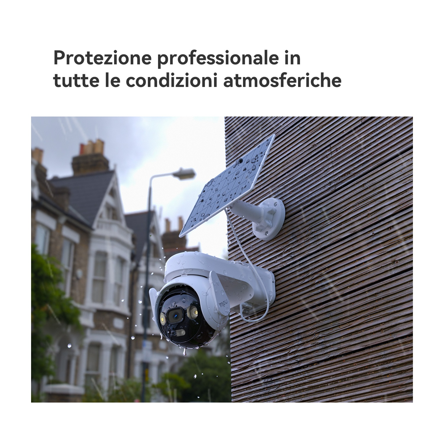 Telecamera di sicurezza bianca con pannello solare montata su muro di legno sotto la pioggia.
