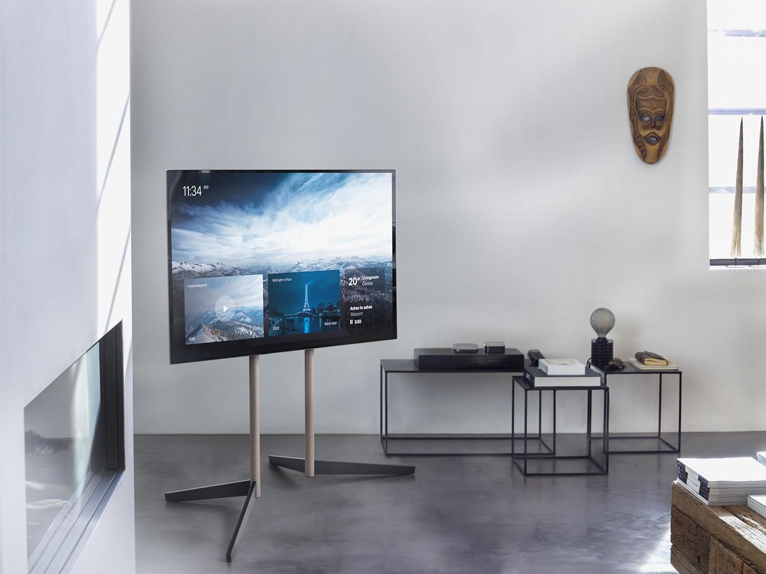 Una sala de estar moderna con TV grande, máscara de madera y muebles minimalistas.