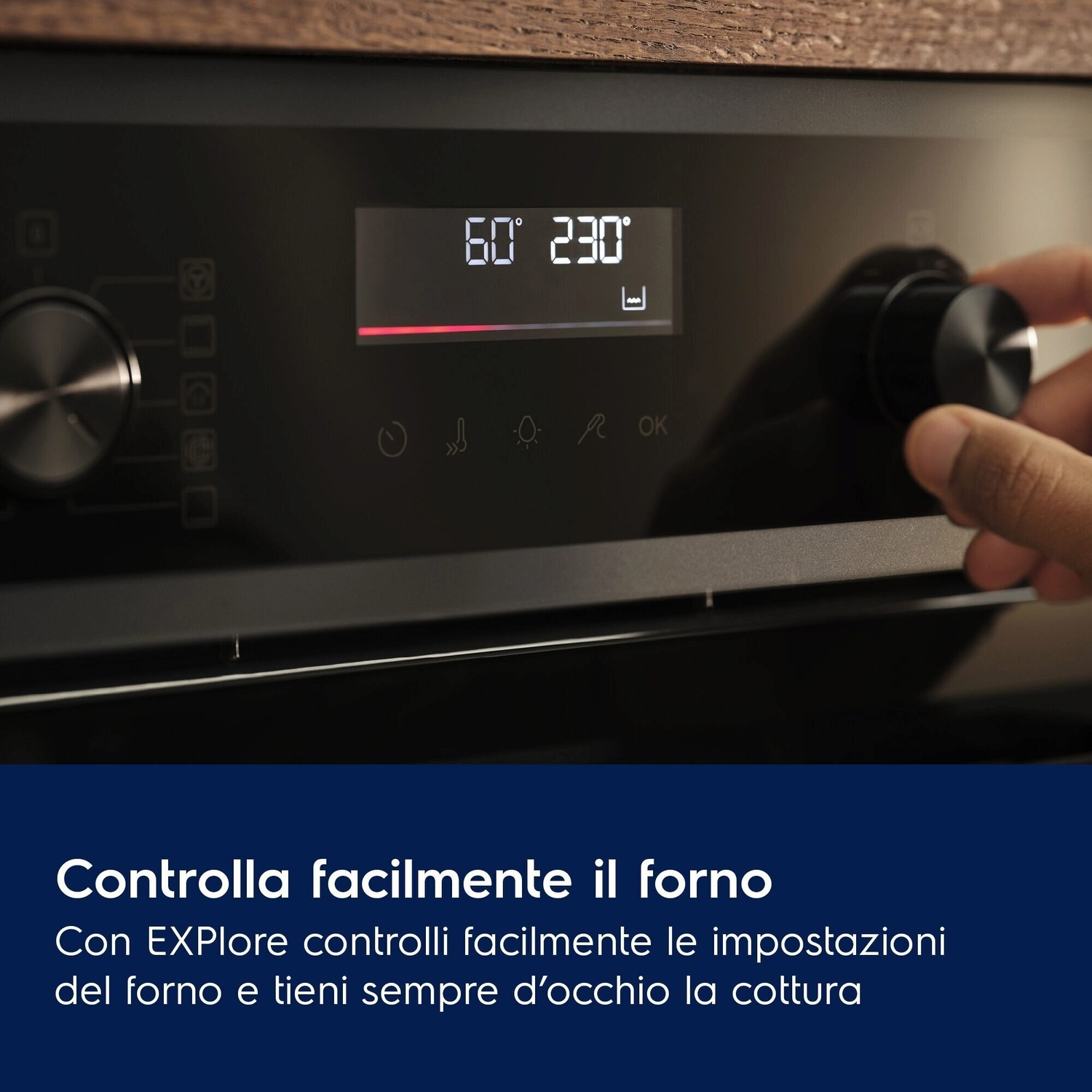 Una mano gira una manopola nera su un forno moderno con display digitale.
