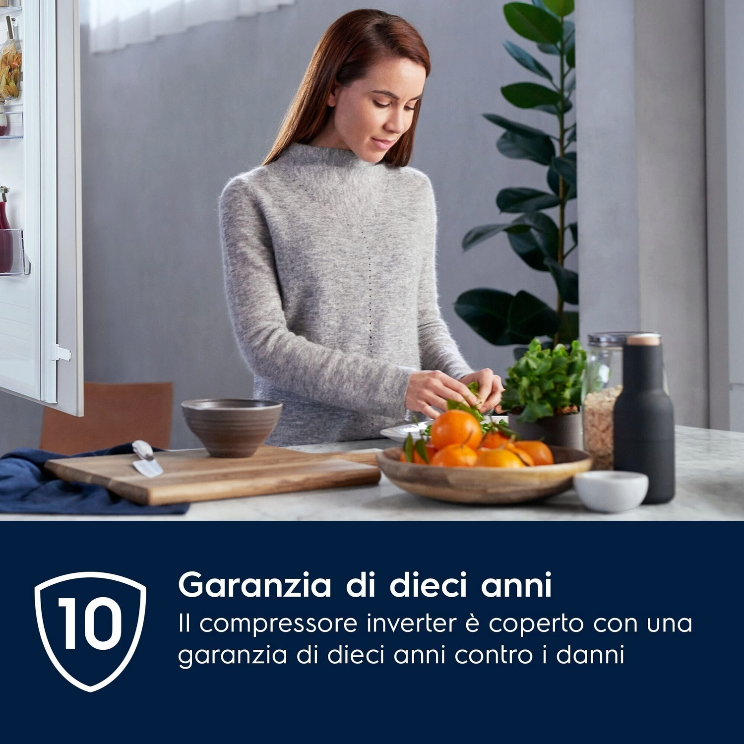 Donna prepara cibo vicino a frigo e frutta.