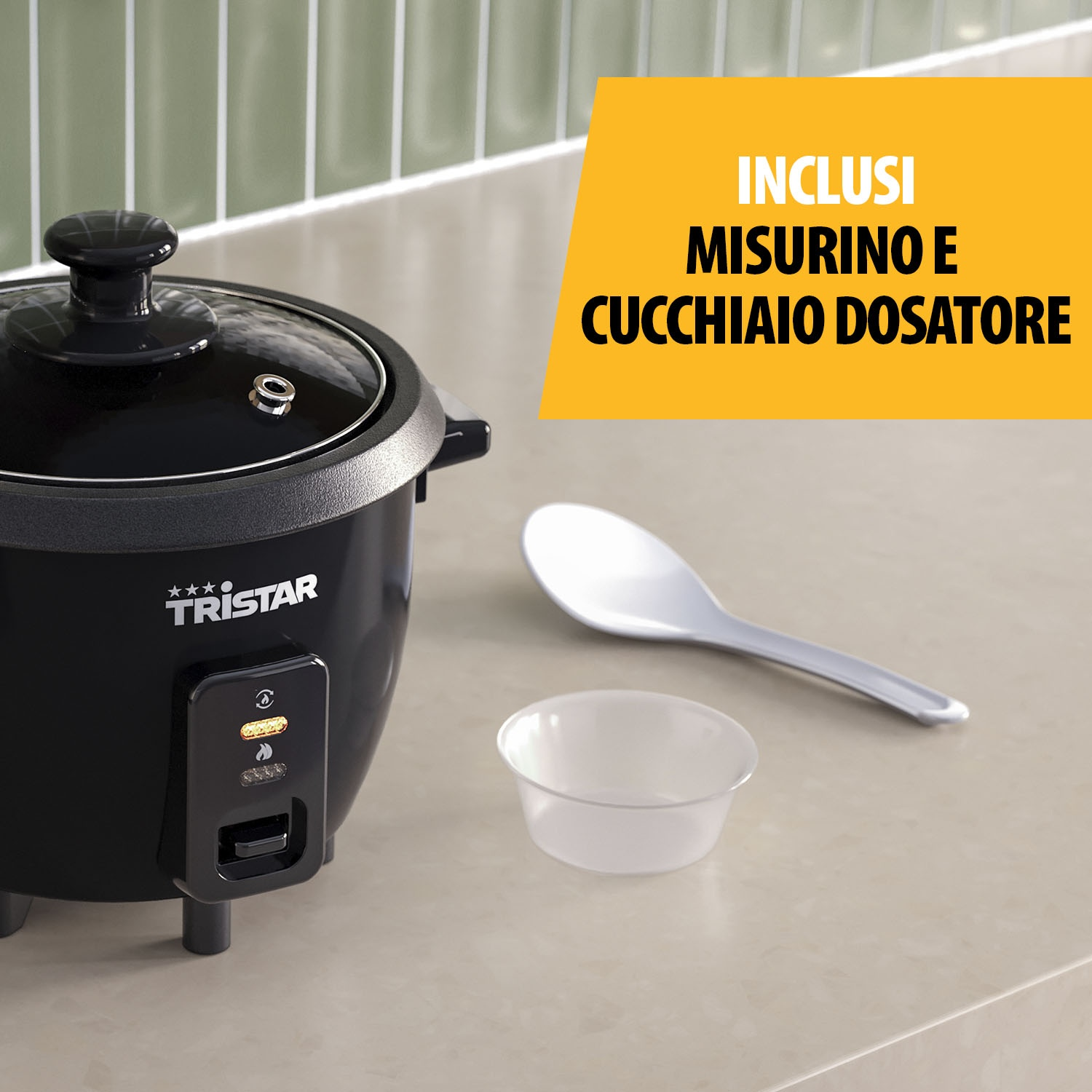 Una pentola per riso nera con coperchio in vetro su un piano di lavoro, con cucchiaio e misurino.