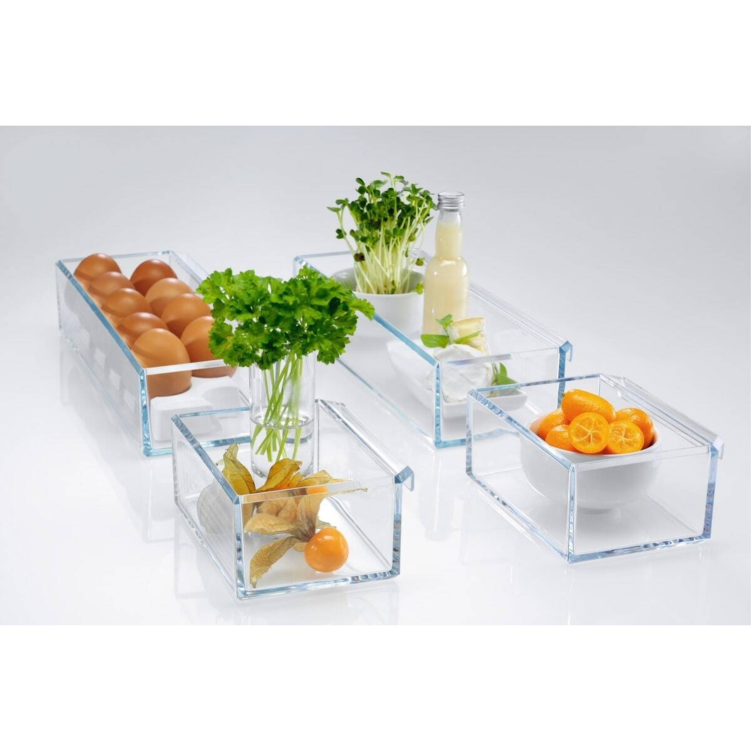 Contenitori trasparenti con uova, prezzemolo, germogli, kumquat e physalis su sfondo bianco.