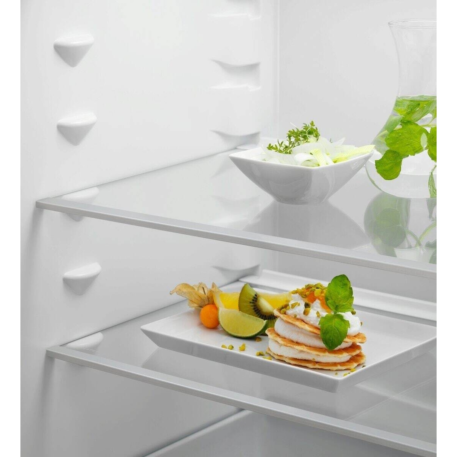 Un dolce con pancake e panna, guarnito con pistacchi e menta.