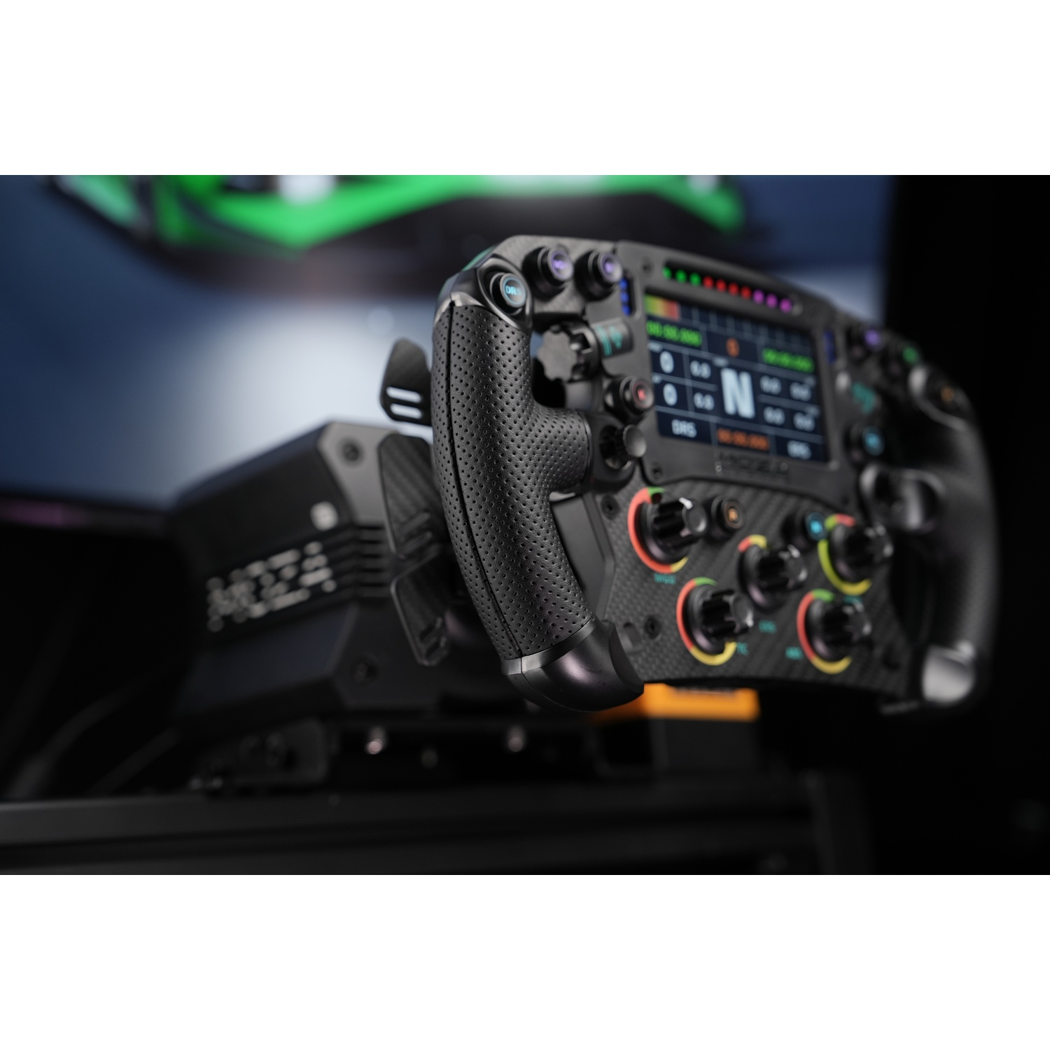 Un volante da corsa nero con schermo e pulsanti, con un'auto verde su un monitor sullo sfondo.