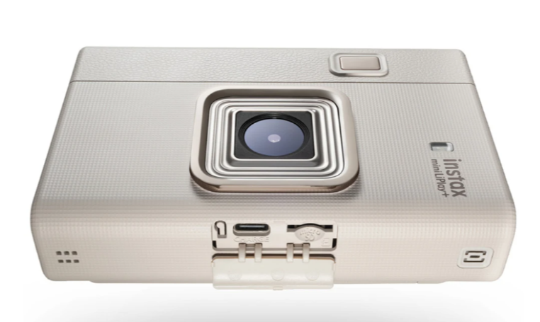 Kremowy aparat Instax Mini LiPlay+ z obiektywem i portami.