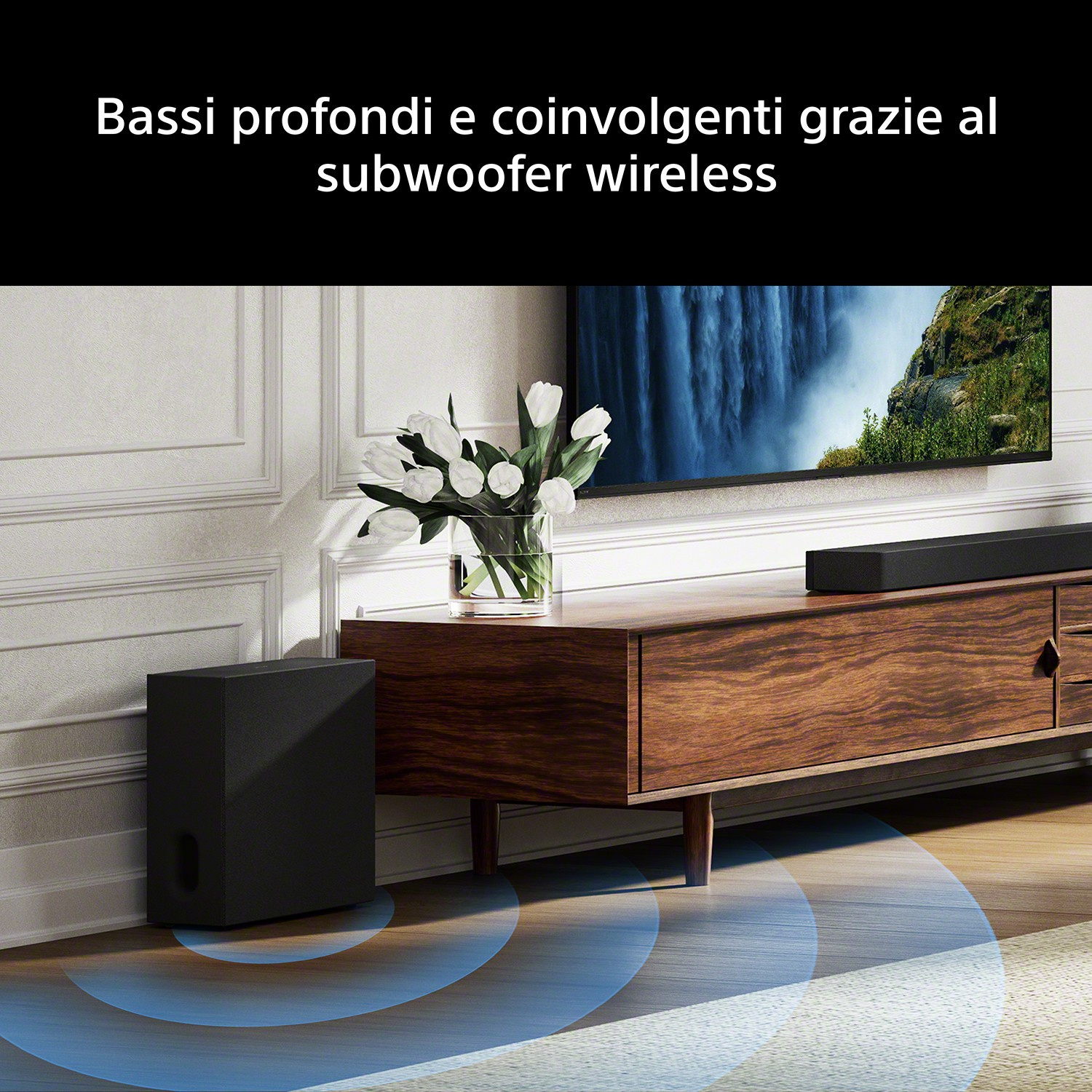 Subwoofer nero accanto a un mobile in legno con TV. Onde sonore visibili.