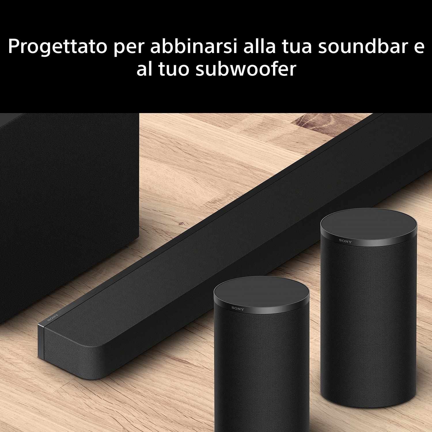Altoparlanti e soundbar neri su pavimento in legno.