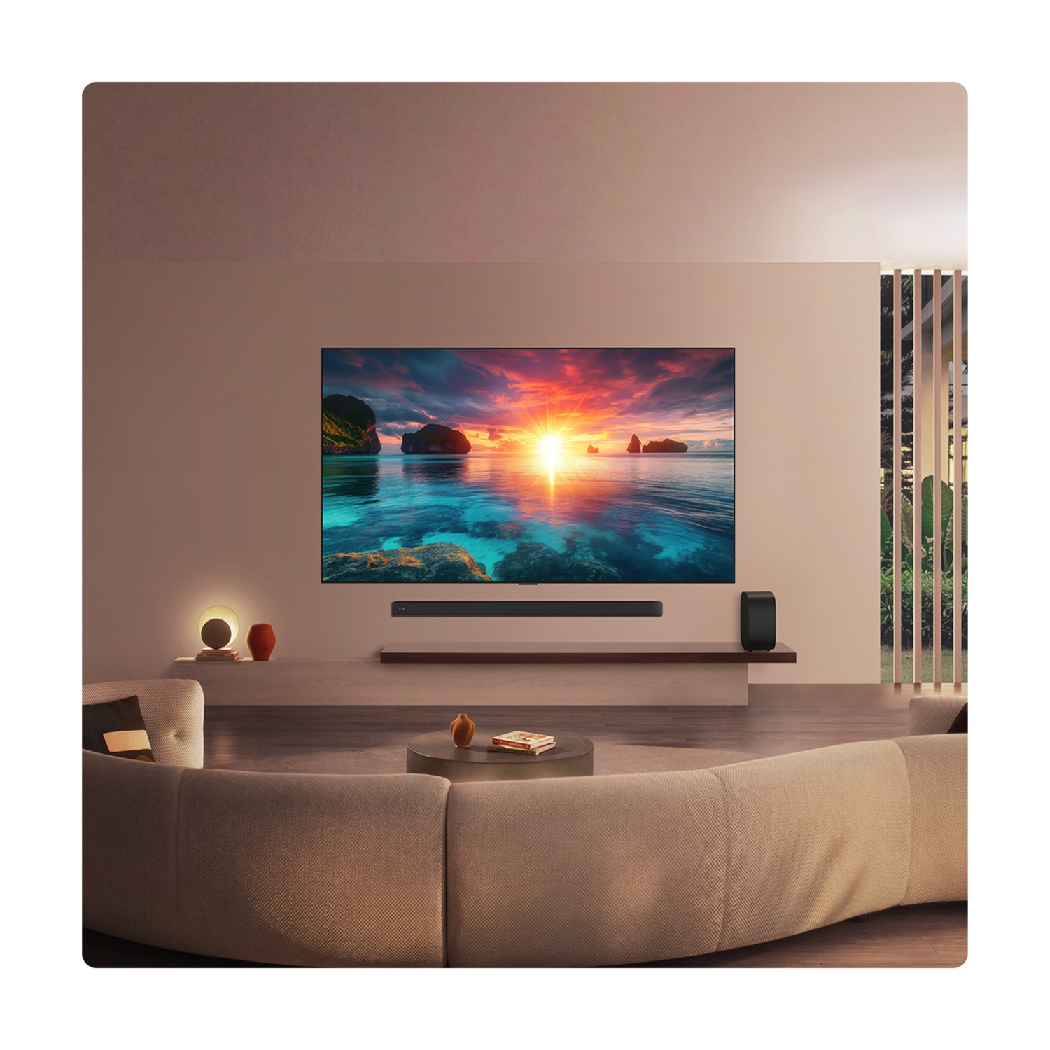 Soggiorno moderno con grande TV che mostra un tramonto, divano curvo e soundbar.
