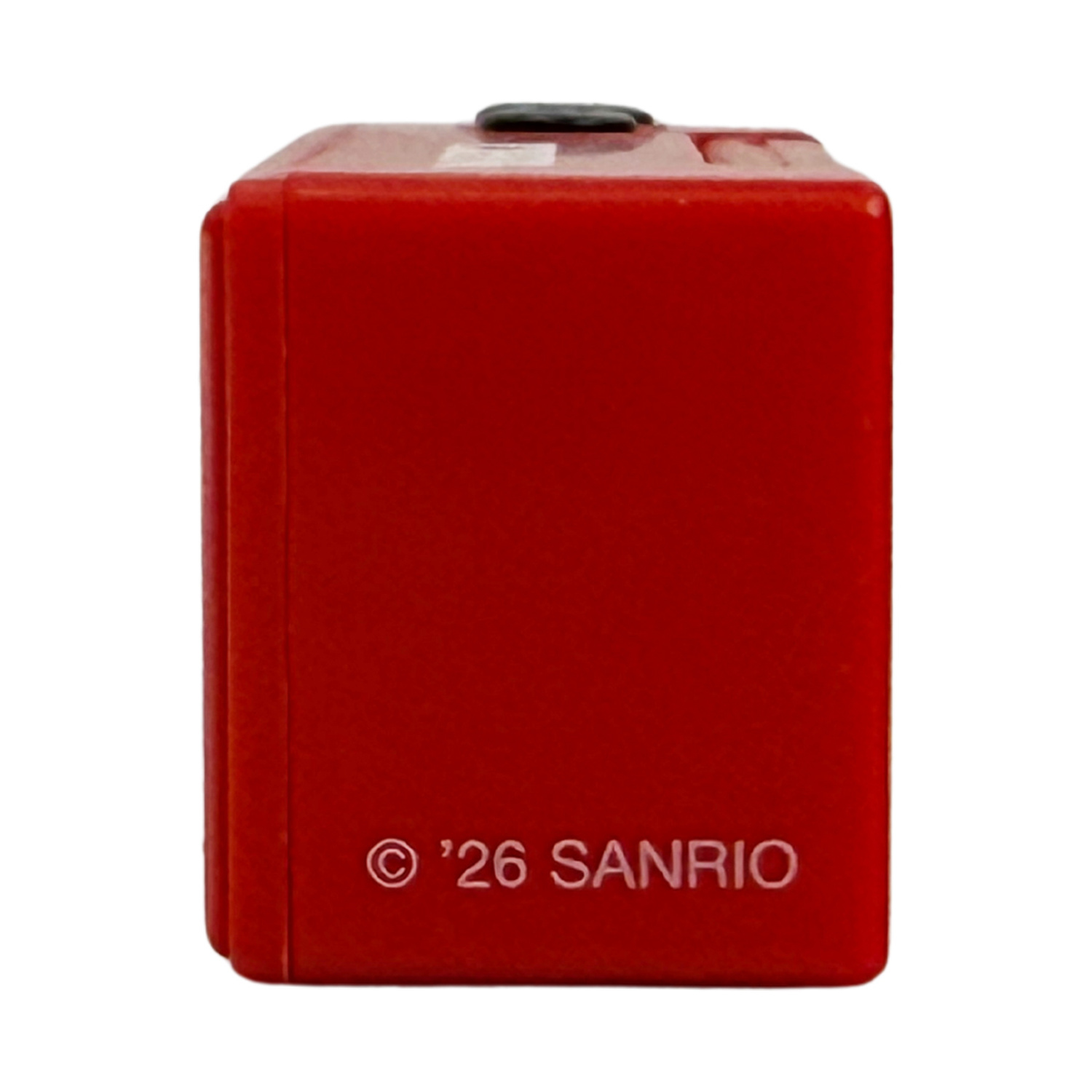 Un cubo rosso con un pulsante nero in alto e la scritta '26 SANRIO'.