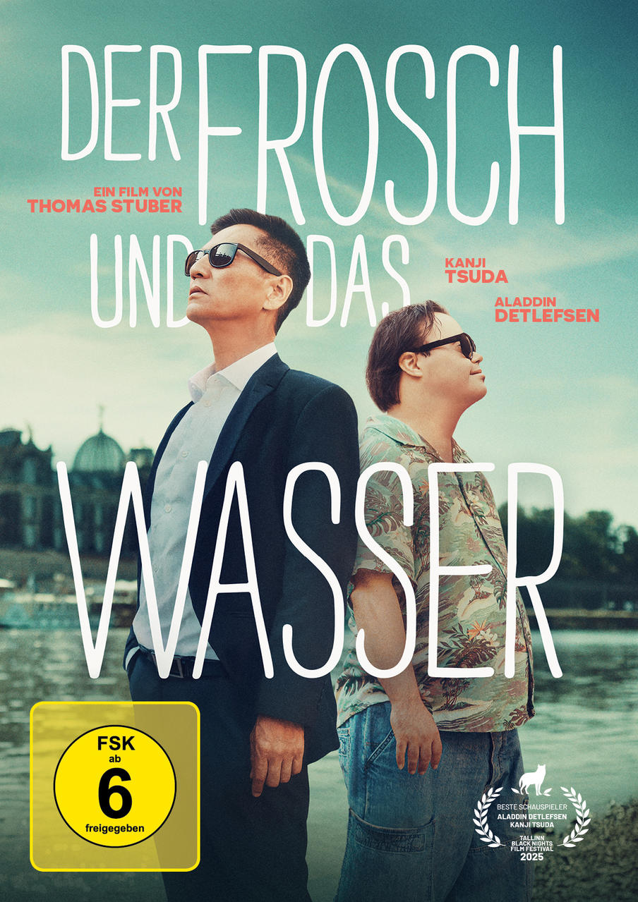 Zwei Männer stehen am Wasser. Einer trägt Anzug, der andere Blumenhemd. Text: Der Frosch und das Wasser.