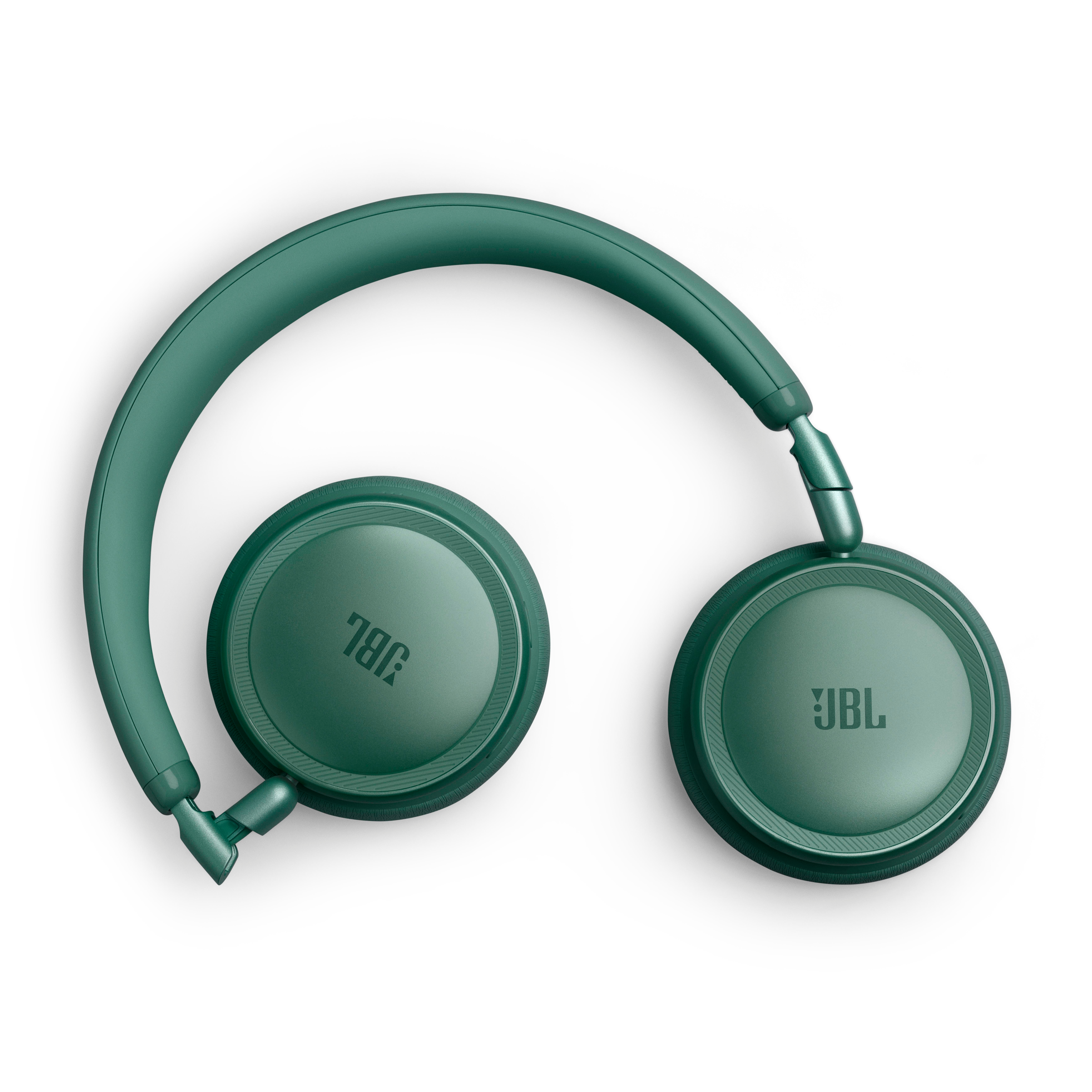 Grüne JBL Kopfhörer, auf weißem Hintergrund liegend, mit Kopfband über den Ohrmuscheln.
