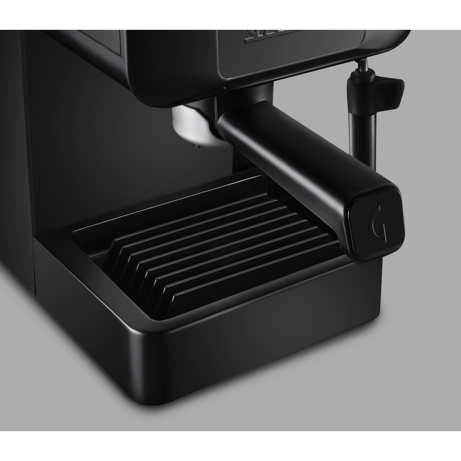 Primo piano di una macchina da caffè nera con vaschetta raccogligocce e manico.