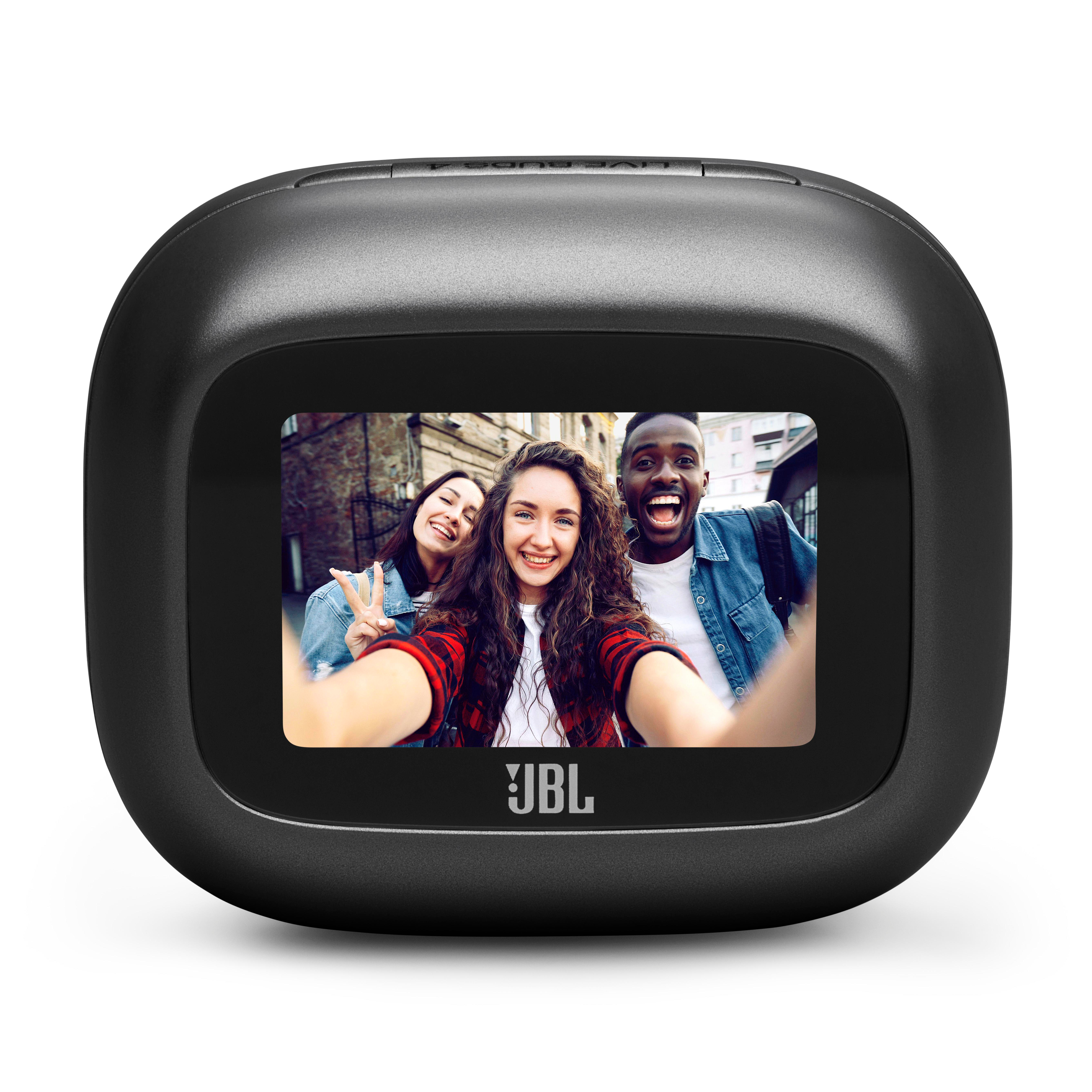 Drei lachende Freunde machen ein Selfie vor einer Backsteinmauer. JBL-Logo unten.