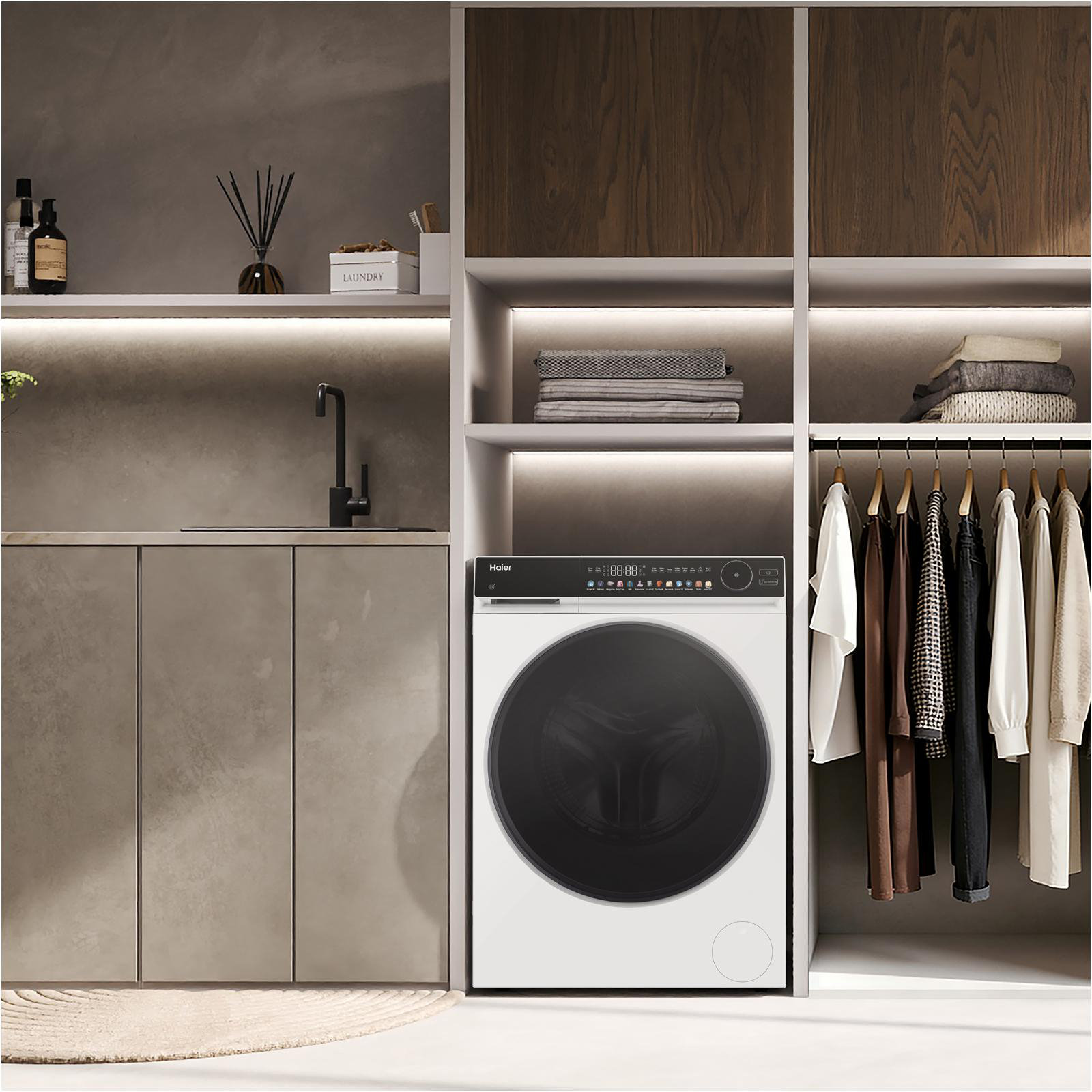 Moderner Waschraum mit weißer Haier-Waschmaschine, Spüle und offenem Schrank.