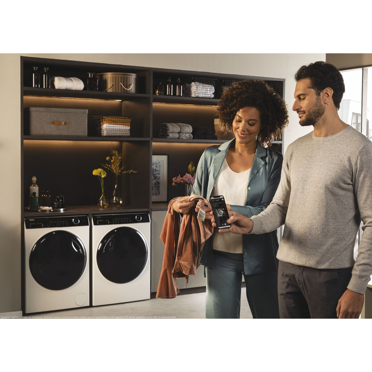 Man en vrouw kijken naar telefoon in wasruimte met twee wasmachines.