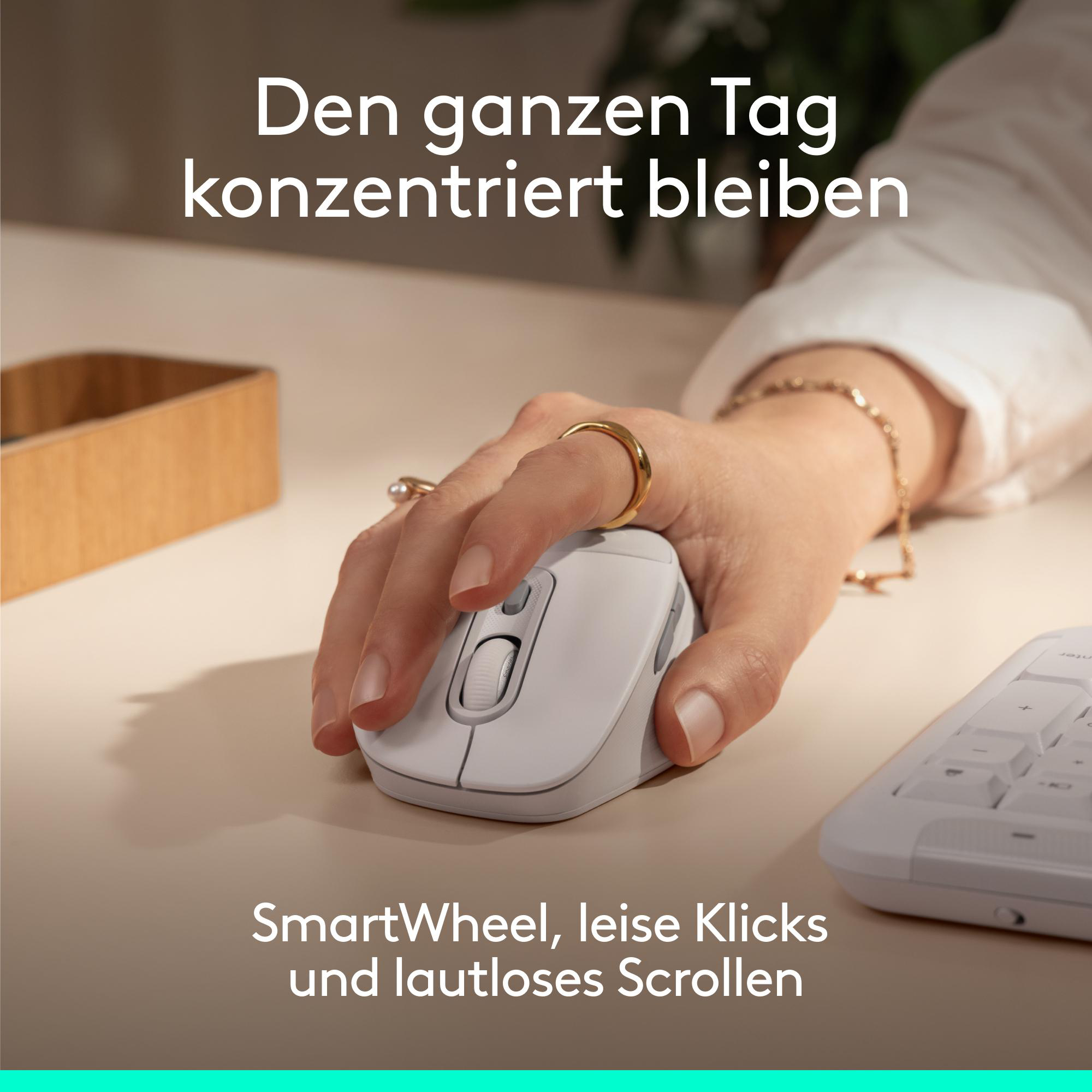 Eine Hand benutzt eine weiße Maus mit einem goldenen Ring und einem Armband.