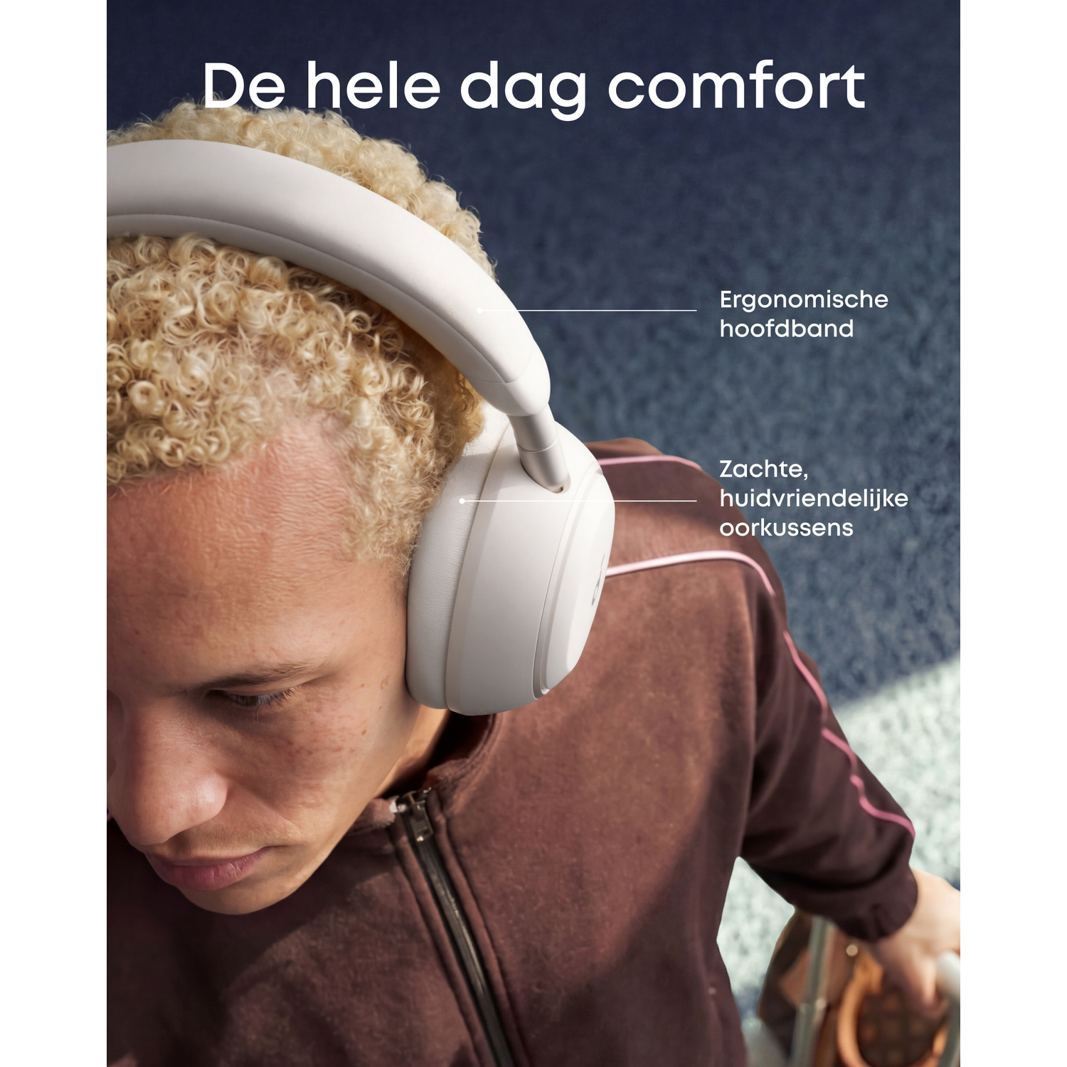 Persoon met blonde krullen draagt witte koptelefoon met ergonomische hoofdband.