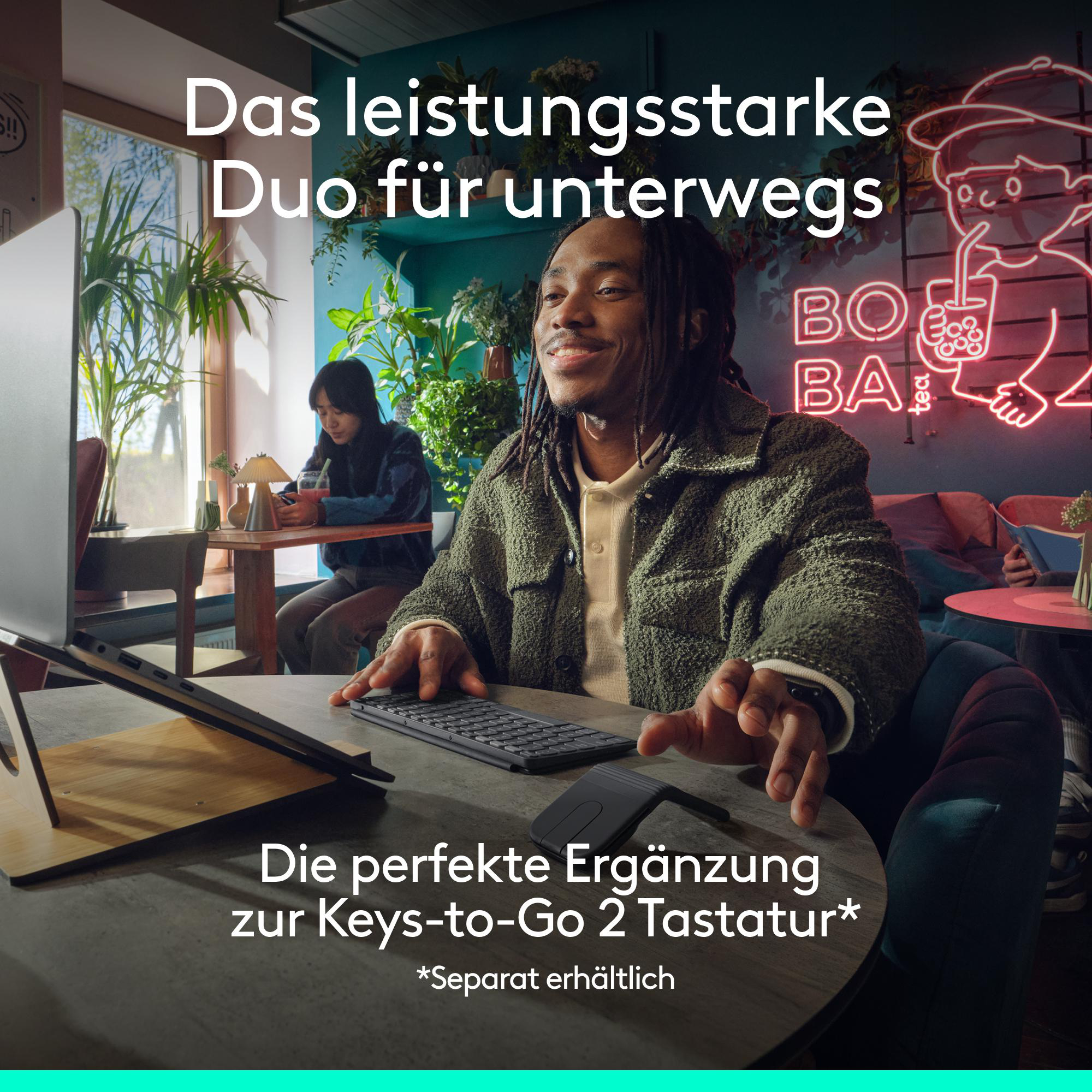 Ein Mann tippt auf einer Tastatur, eine Frau sitzt im Hintergrund.