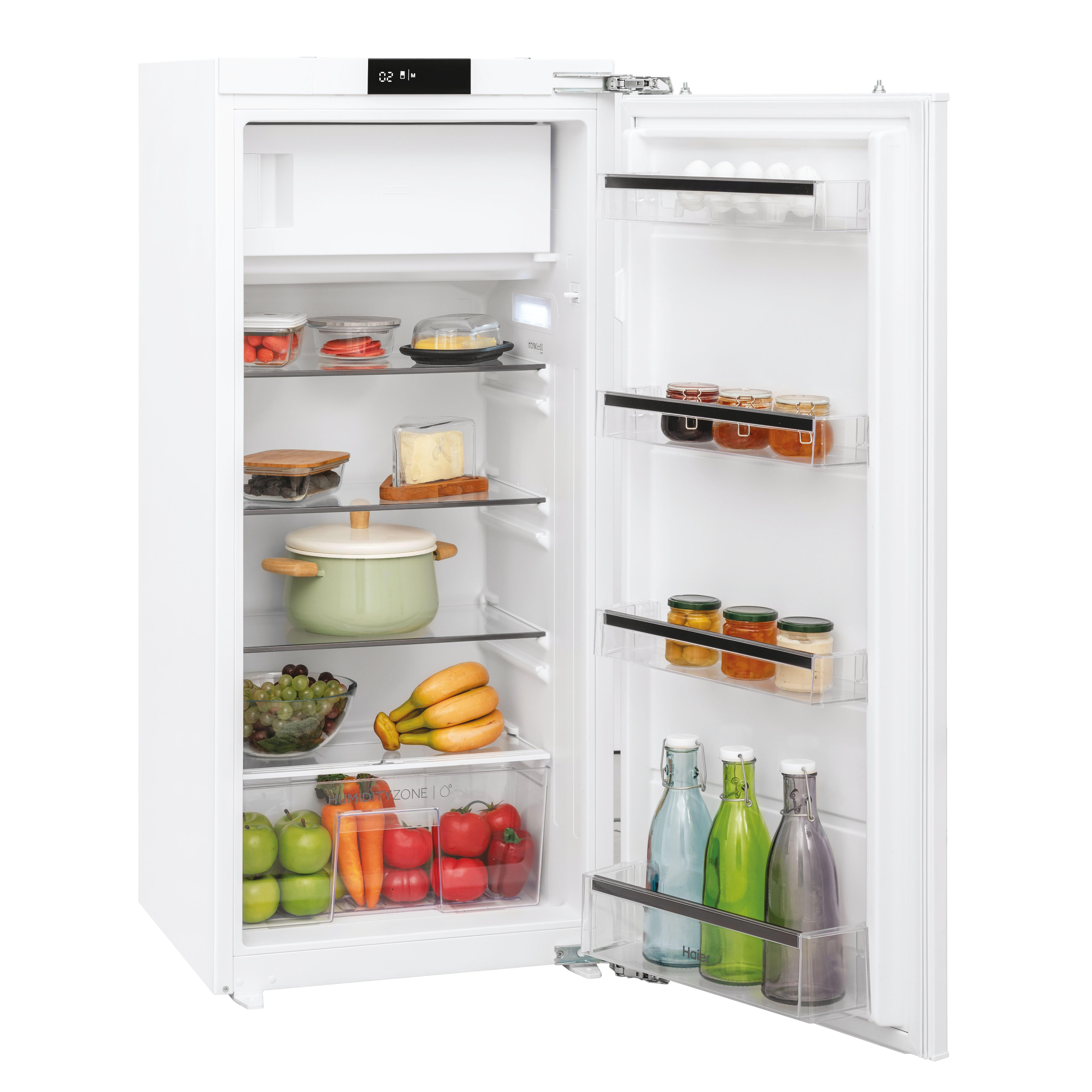 Ein offener weißer Kühlschrank mit Lebensmitteln wie Obst, Gemüse, Käse und Gläsern.